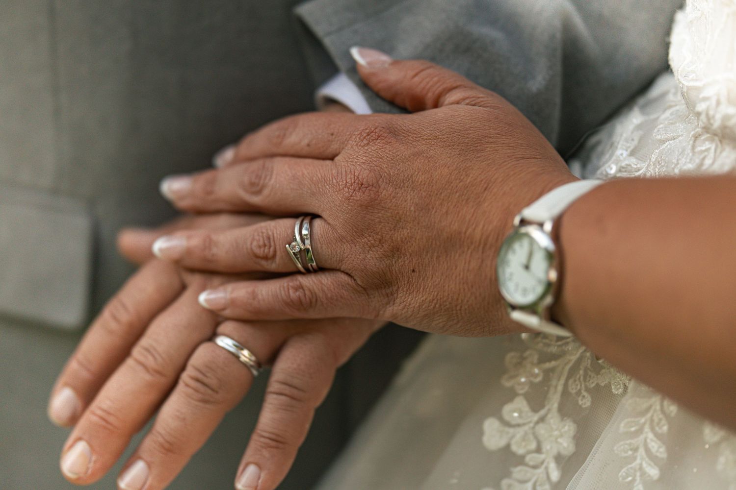 Detailed image of hands laid ontop with wedding rings