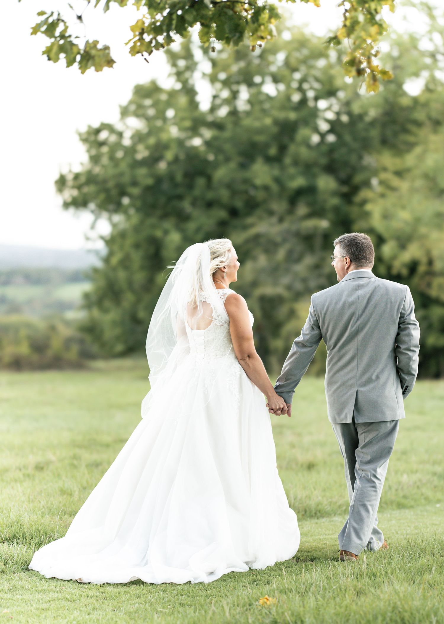 Candid moment of newly married couple sharing a romantic walk in the countryside.