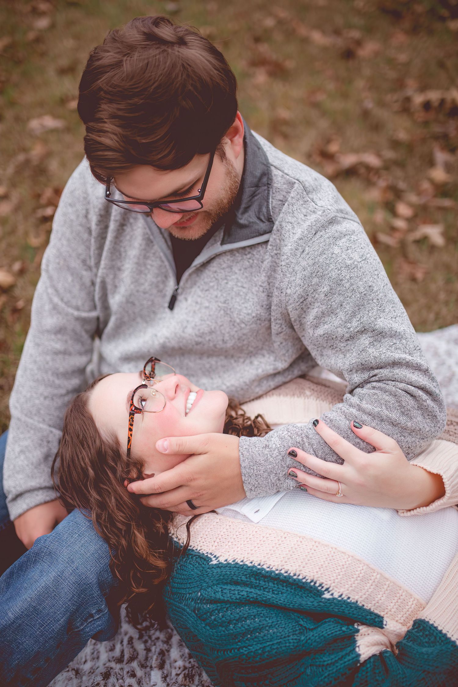 Intimate couple portrait with autumn leaves in background showing tender moment.