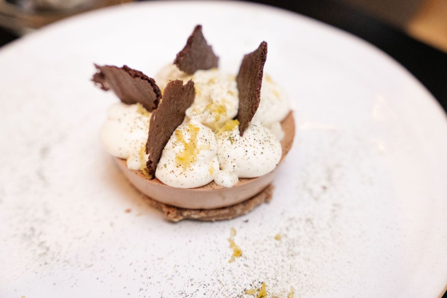 Chocolate Easter egg cracked open on a white surface revealing golden sparkles and decorative elements inside.