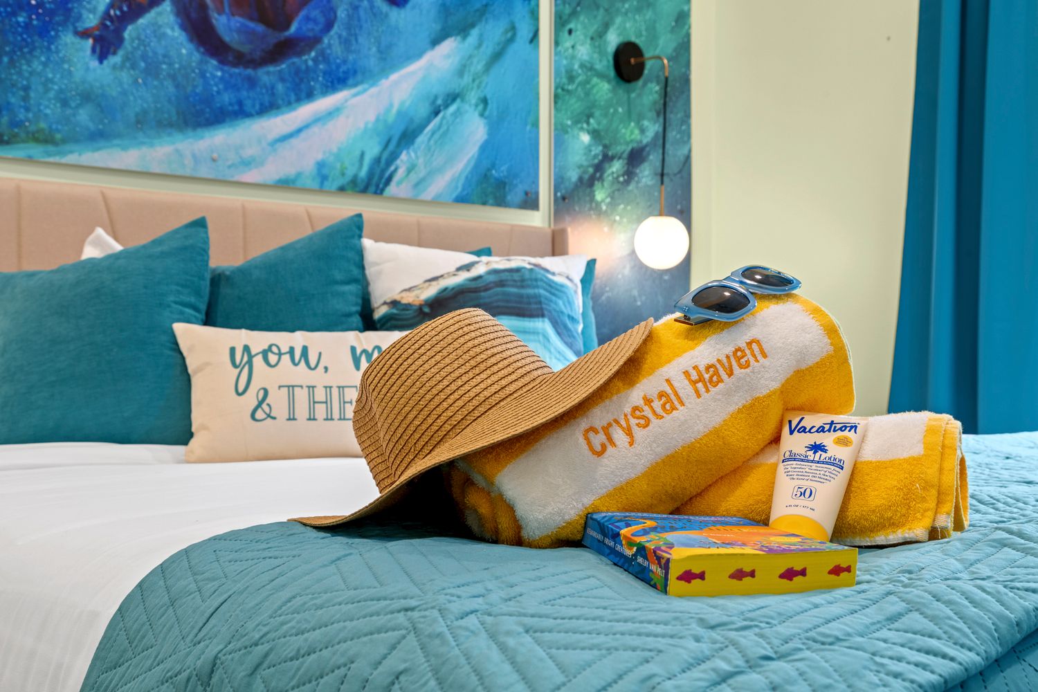 A serene bedroom featuring a teal blue wall and yellow pillows on a comfortable bed with white bedding.