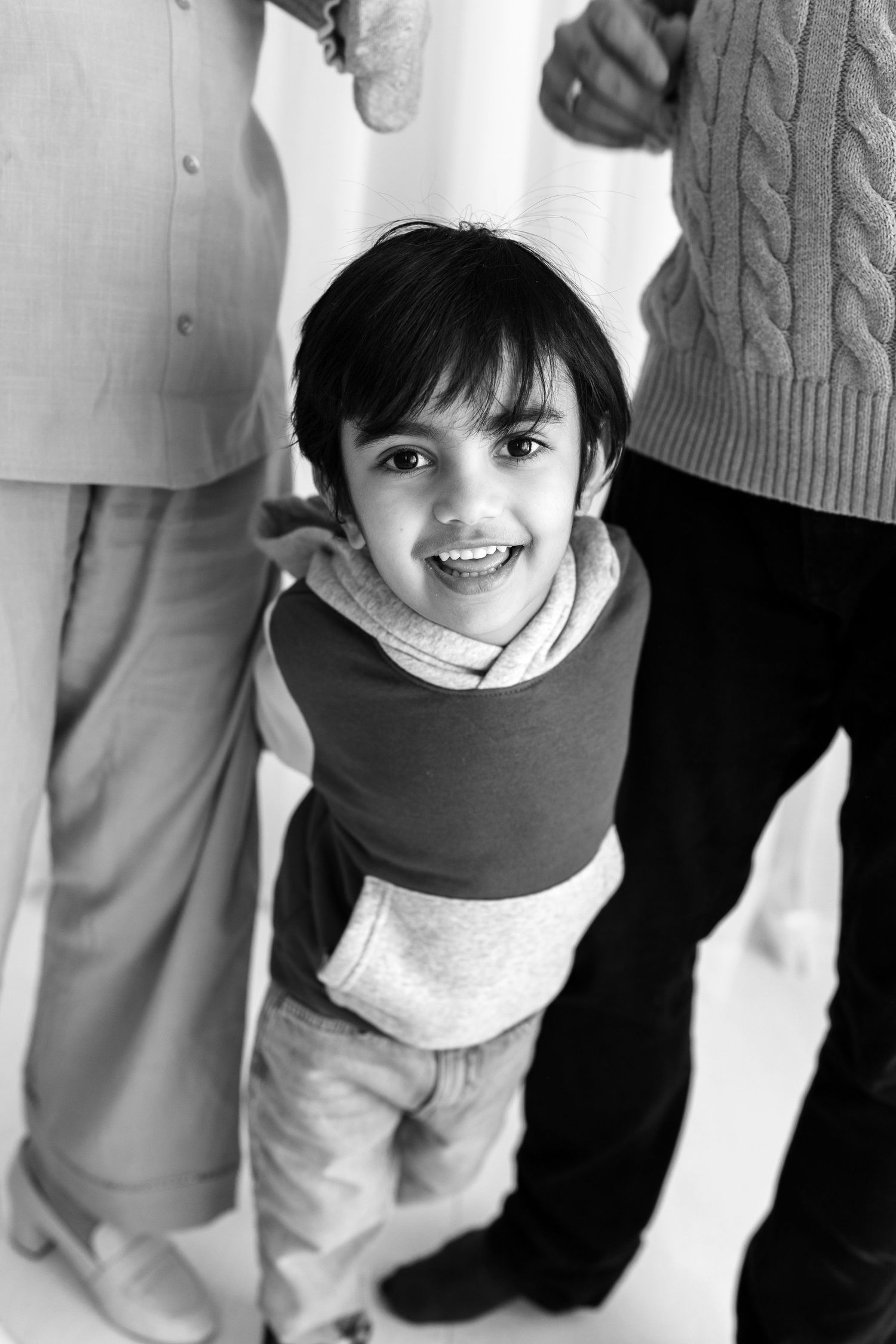 Black and white photo series showing close-up details of children's clothing and poses.