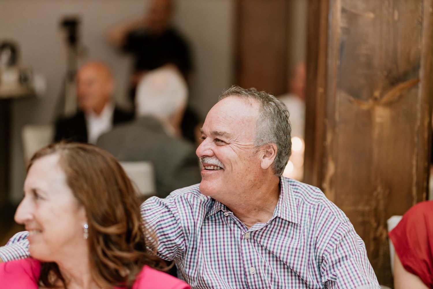 Wedding reception guests share joyful moments during dinner celebration.