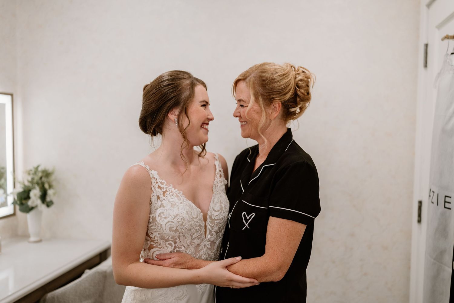 Emotional wedding dress fitting moment captured in natural light.