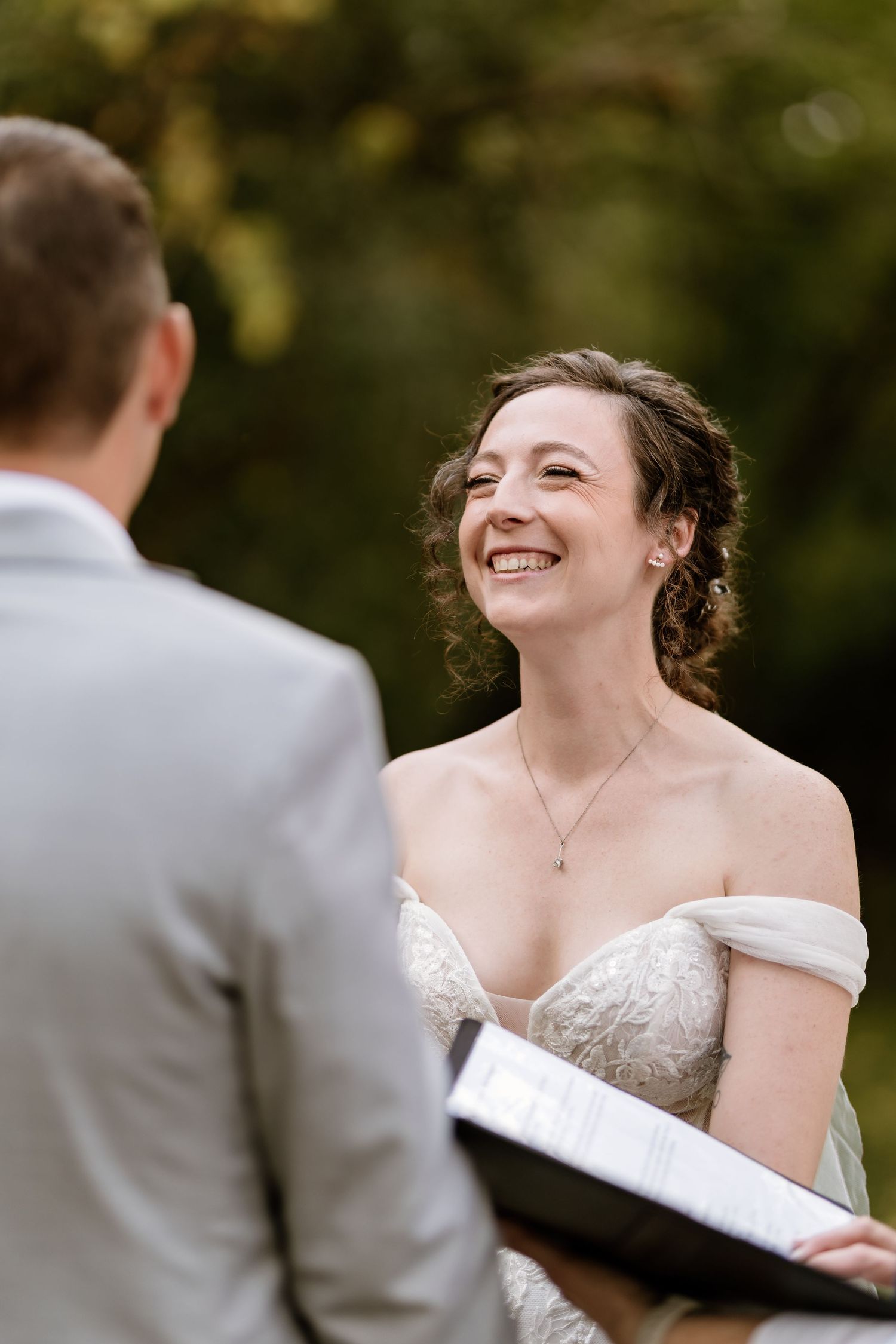 Candid moment during outdoor wedding ceremony with couple exchanging vows.