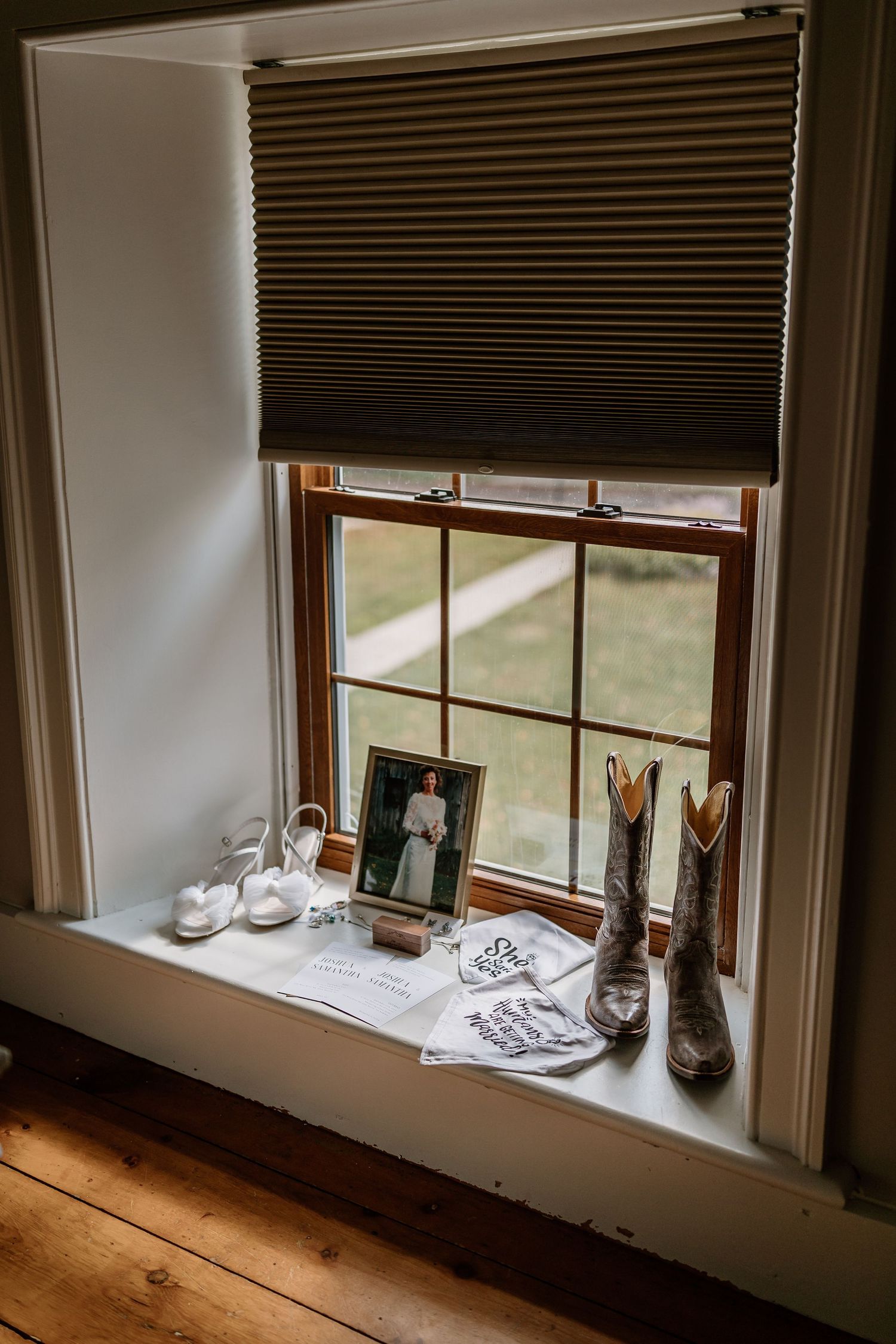 Wedding details arranged on a rustic wooden windowsill with natural light streaming in.