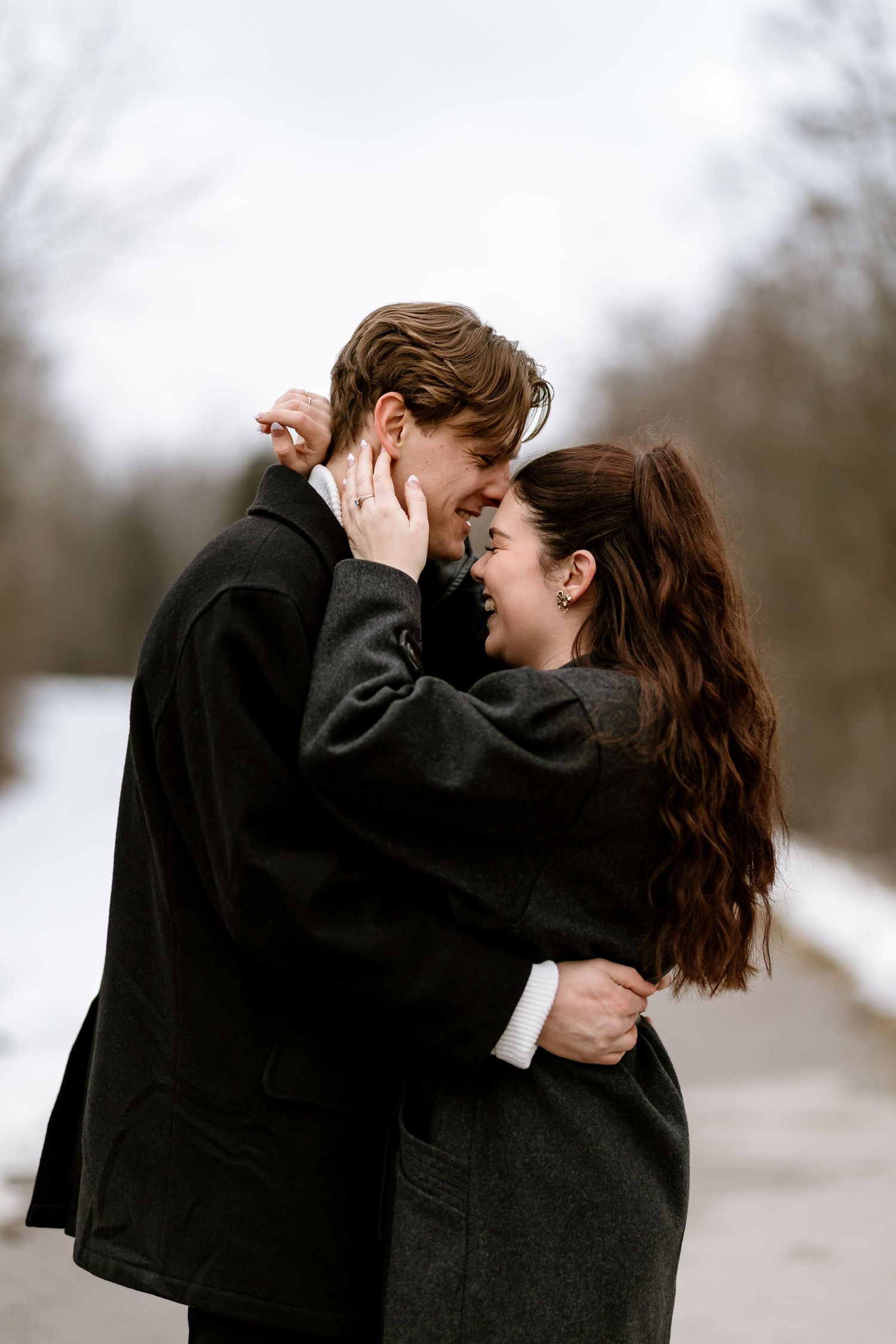 A tender embrace captured in black and white against a snowy winter backdrop.
