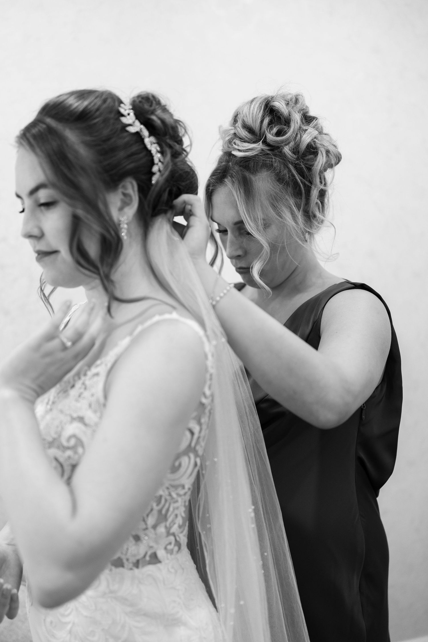 Black and white capture of an intimate wedding dress fitting moment.