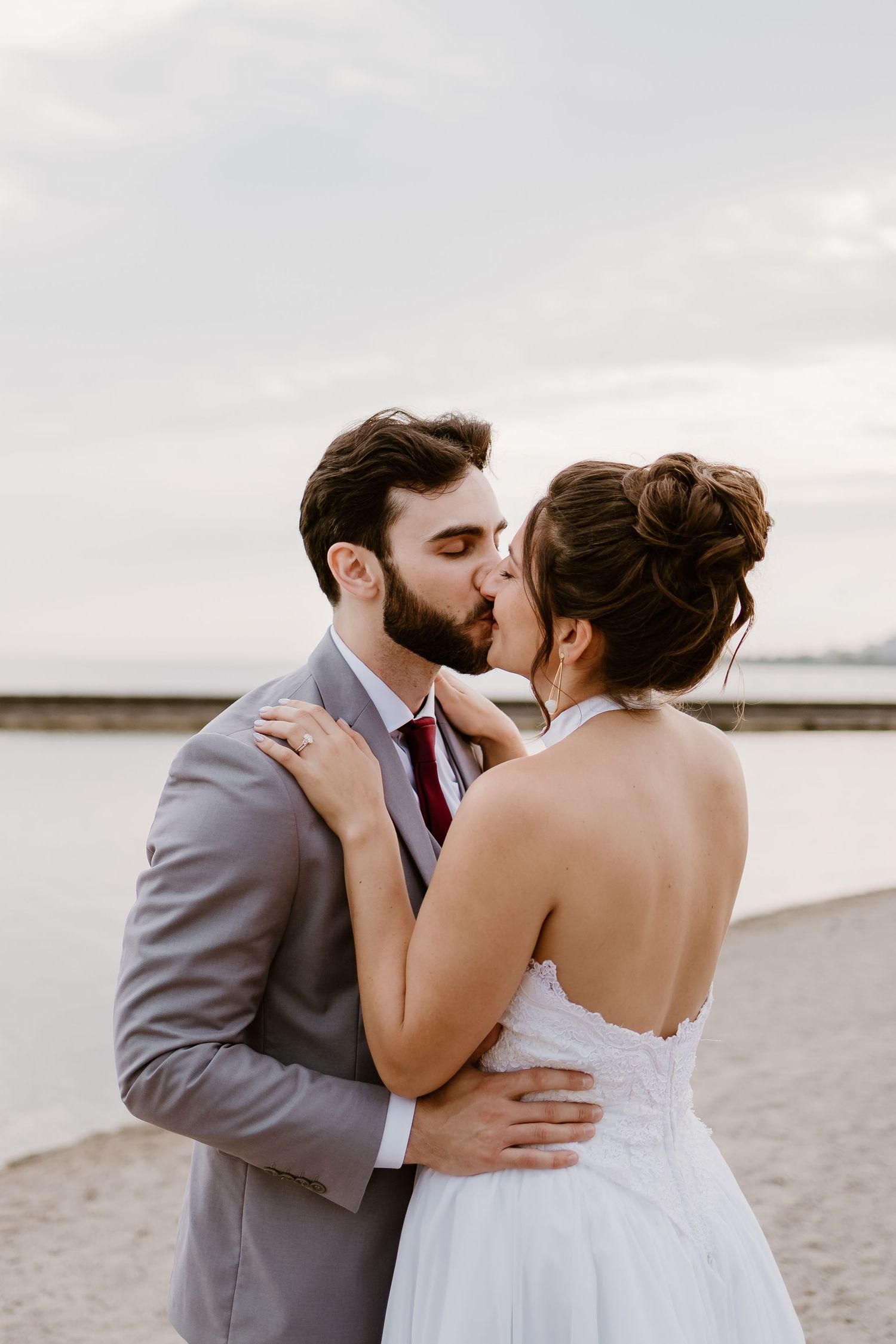 An intimate wedding moment captured on a beach with soft lighting.