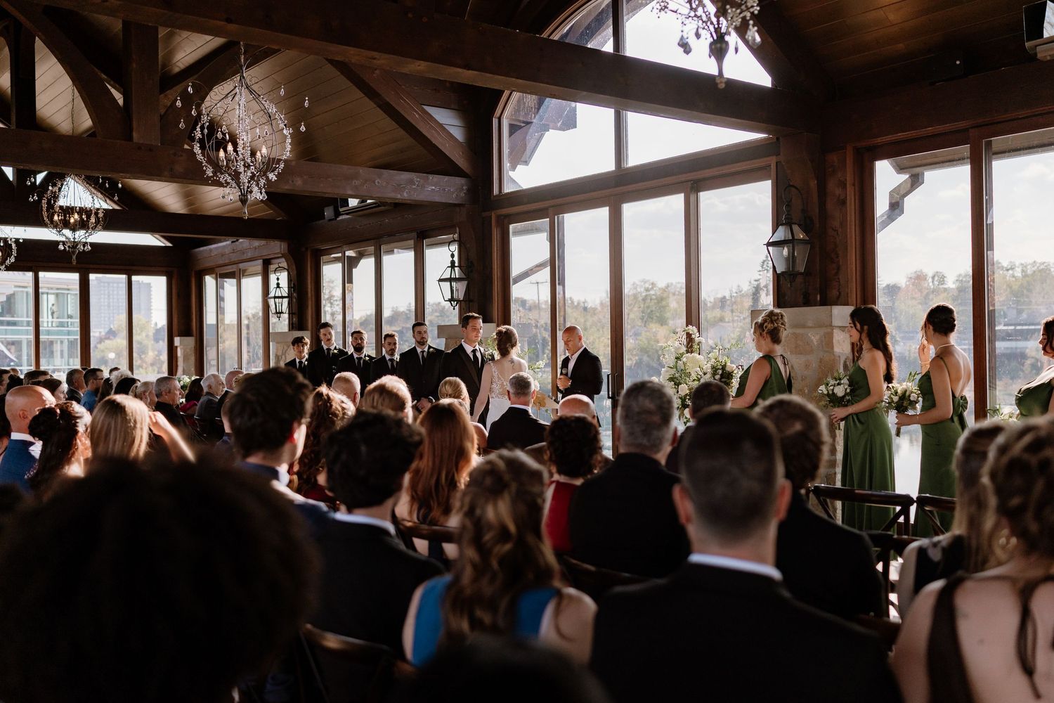 Wide angle view of wedding guests seated in rows during an indoor ceremony.
