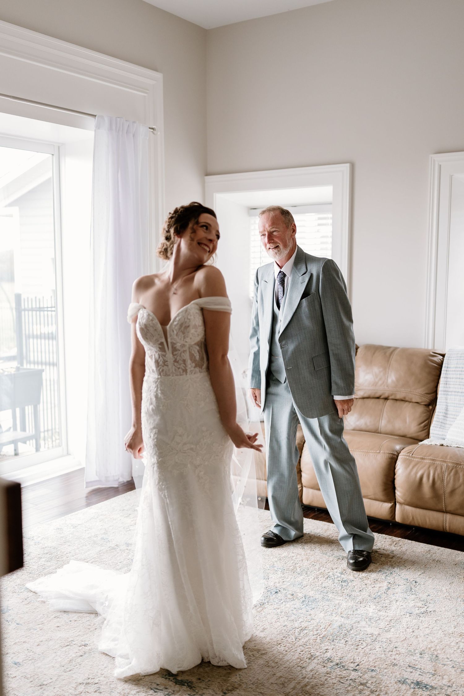 Wedding celebration moment in a bright room with large windows and beige decor.