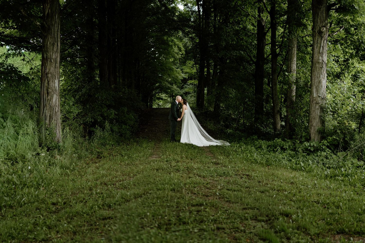 Wedding photography session in a serene wooded area with natural greenery.