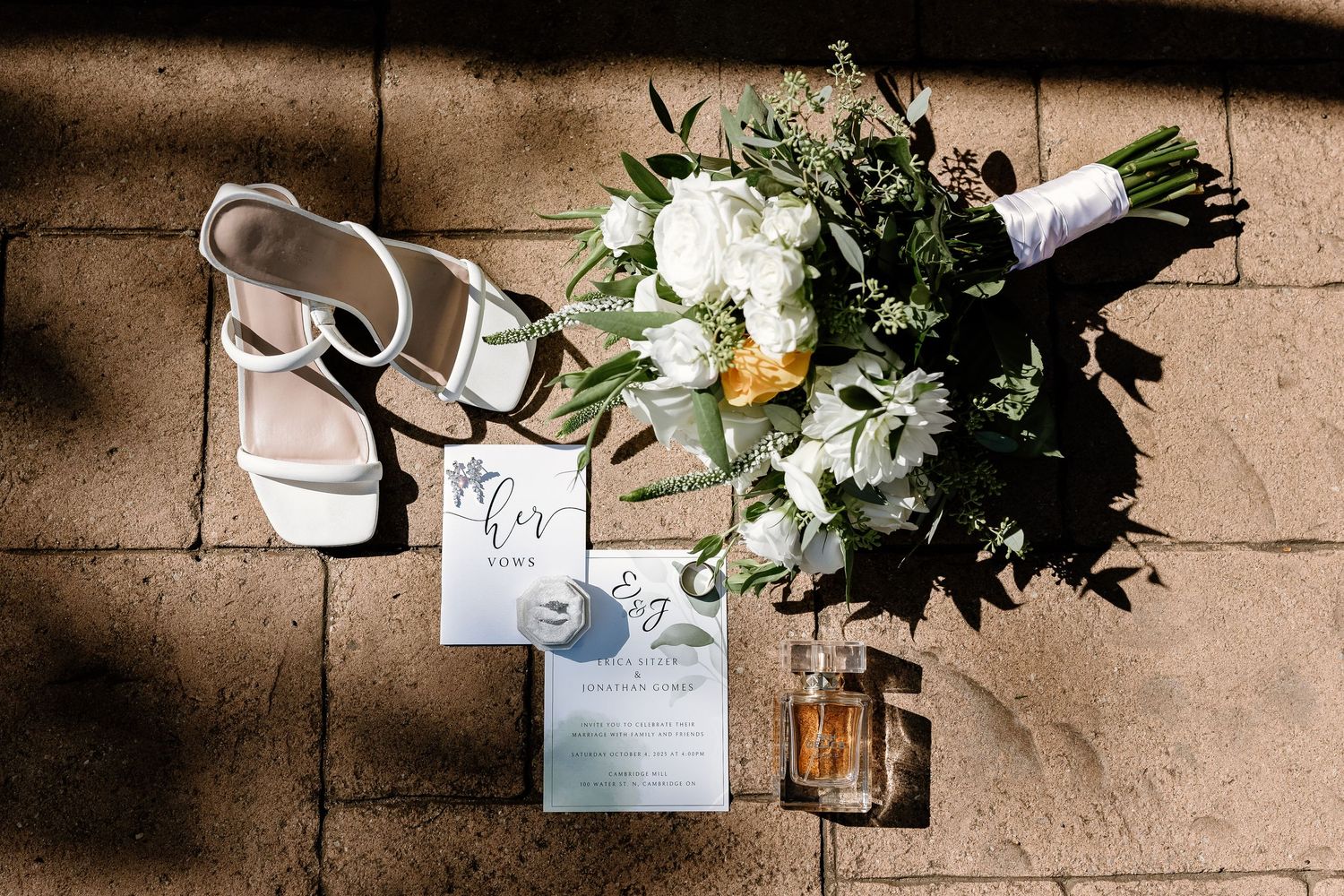 Wedding details including invitations and floral arrangements on a textured surface.