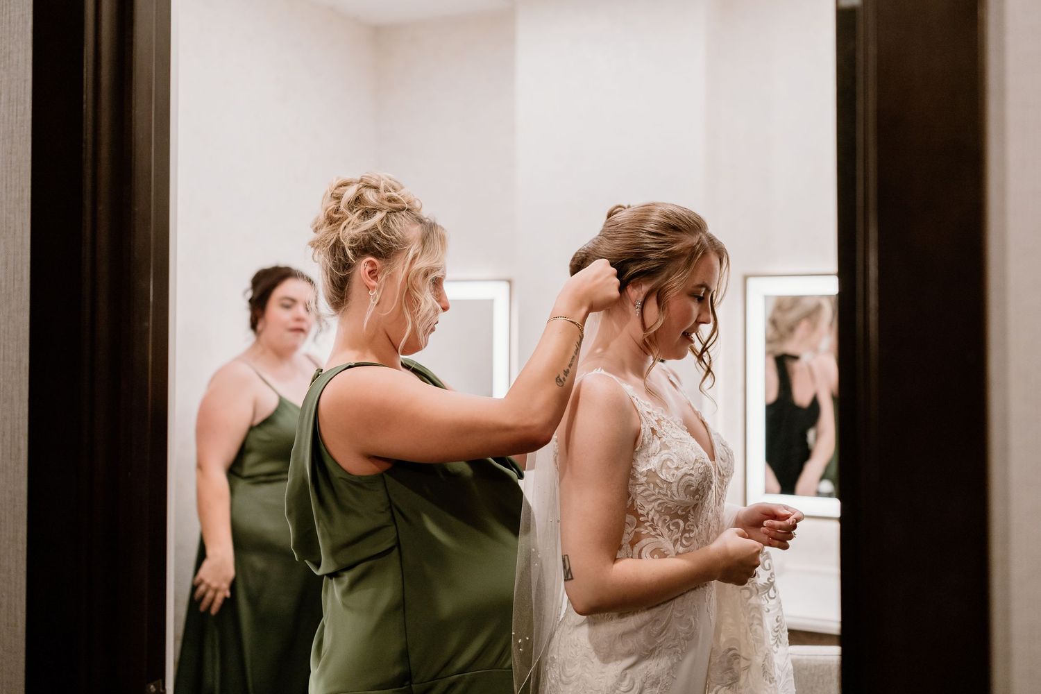 Wedding dress alterations taking place in a well-lit dressing room.