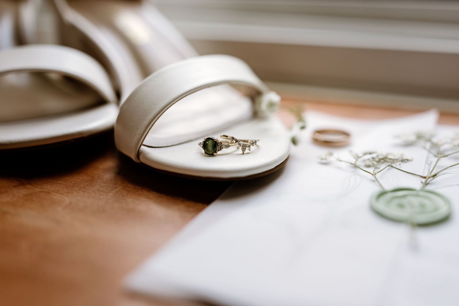 Wedding rings and jewelry arranged artistically on a light surface.