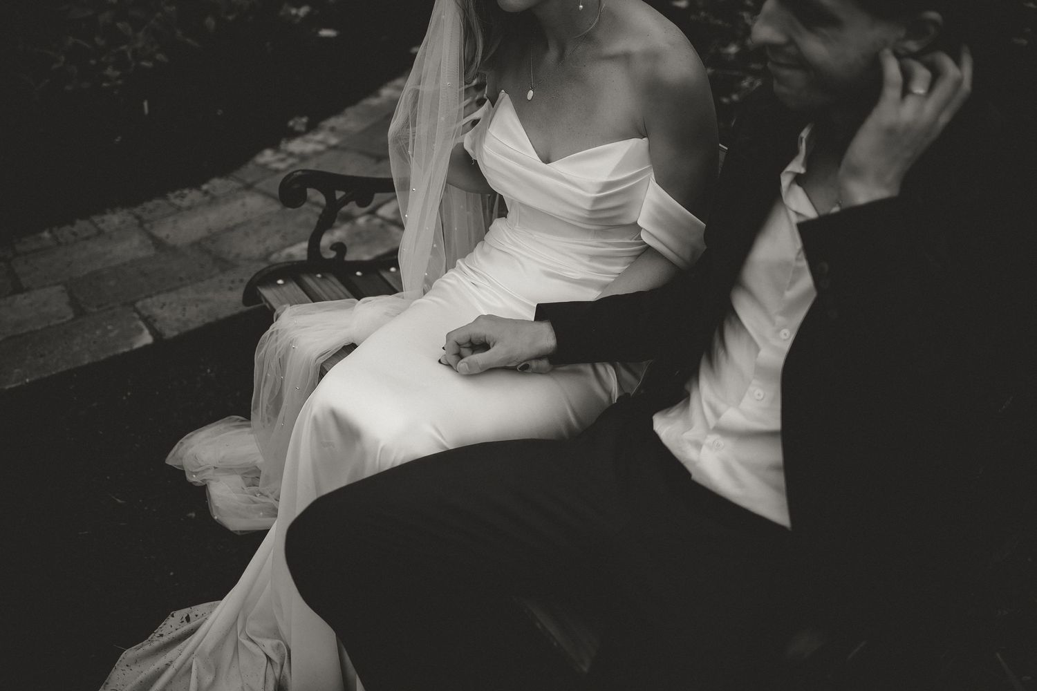 Artistic black and white wedding portrait in intimate garden setting.