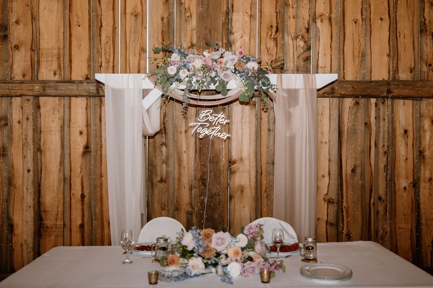Rustic wooden barn wall decorated with string lights for a wedding reception.