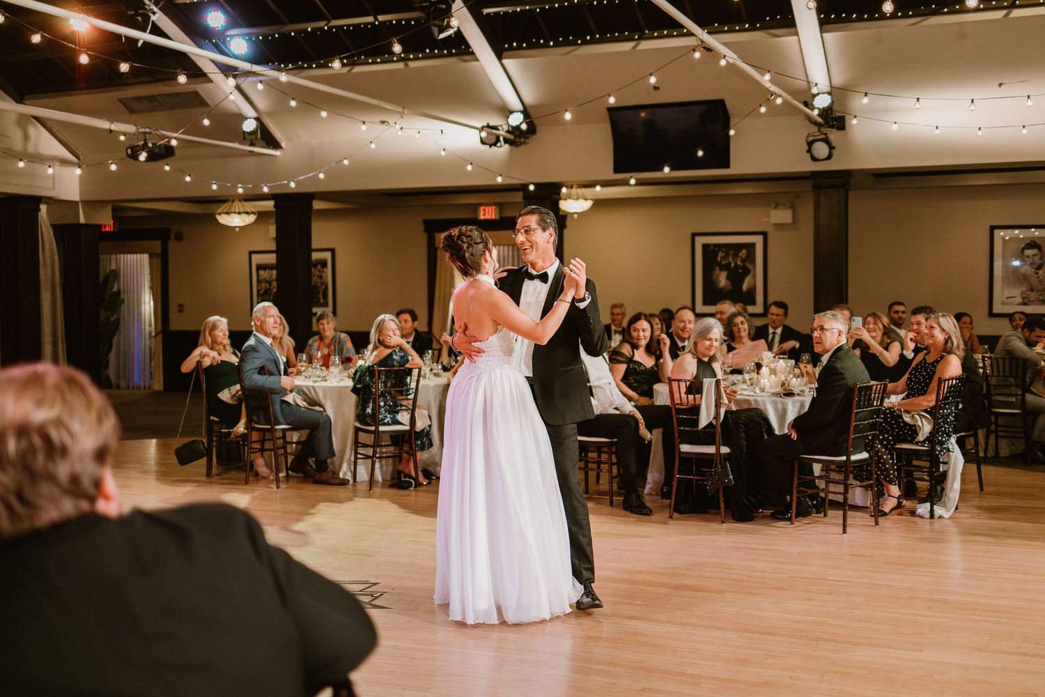 Spacious reception venue with dance floor and tables arranged for wedding celebration.