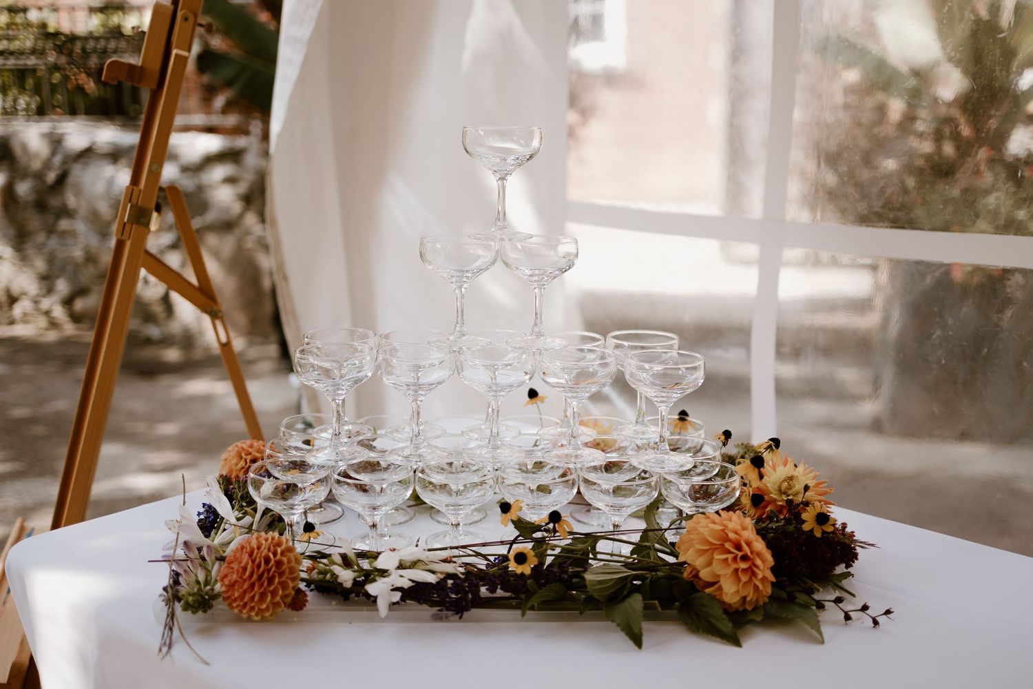 Elegant table decor featuring wine glasses and autumn-colored floral arrangements.