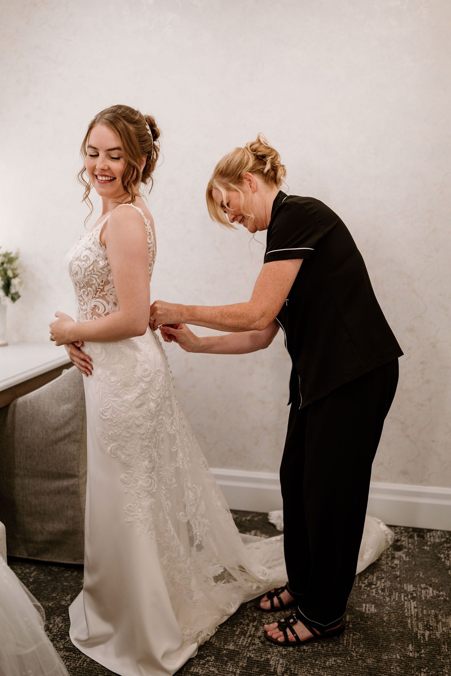 Wedding dress fitting session showing detailed lace work and alterations.