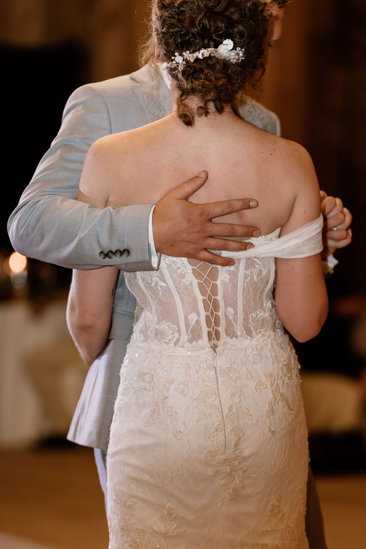 Close-up detail of a white lace wedding dress back with buttons.