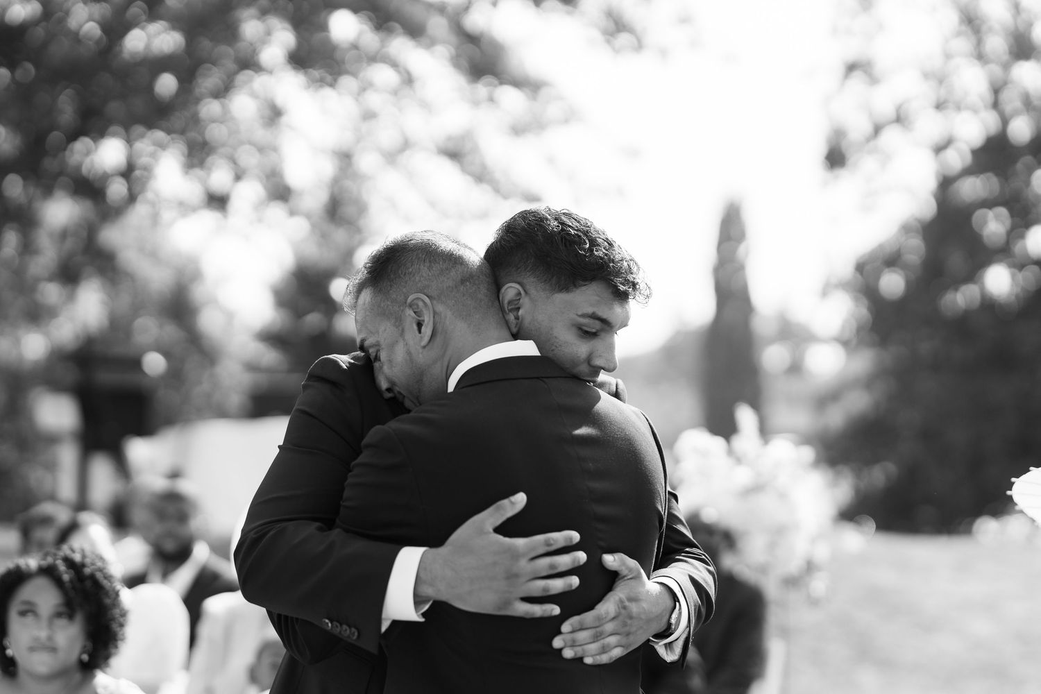 Emotional black and white candid moments shared during an outdoor wedding celebration.