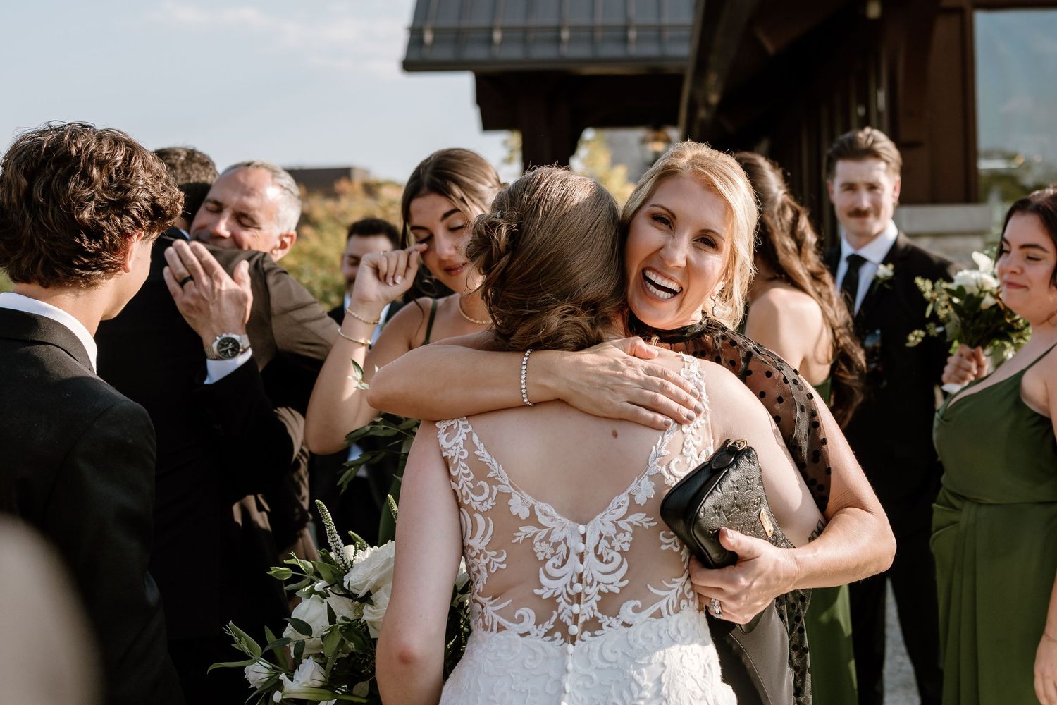 Wedding celebration filled with hugs and tears of joy on outdoor terrace.