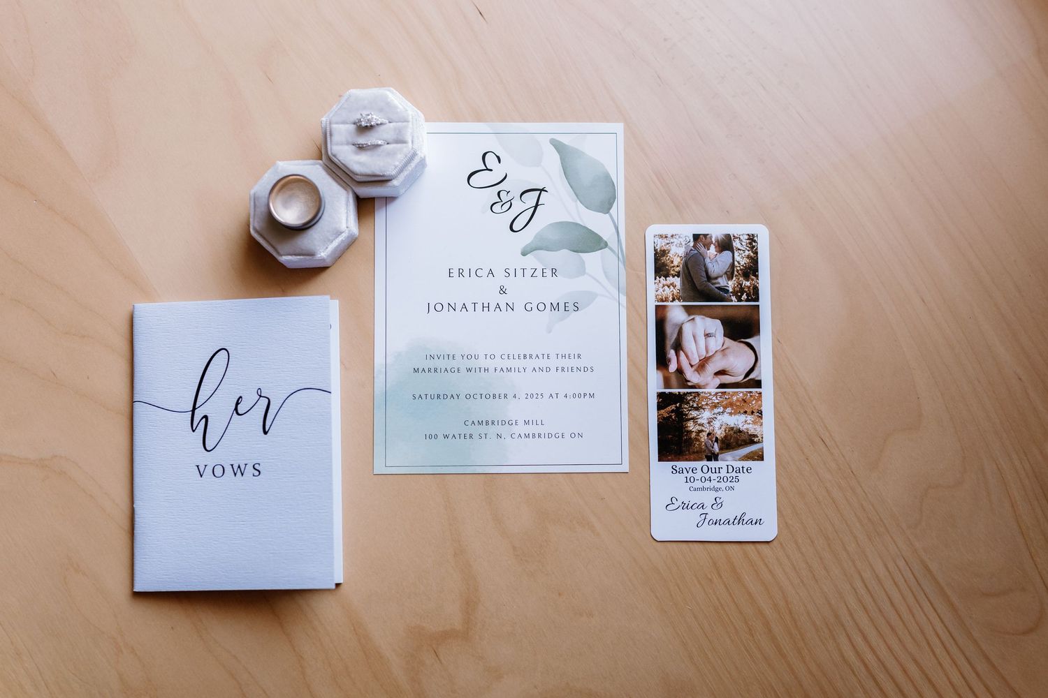Wedding invitations and stationery laid out on a wooden surface.