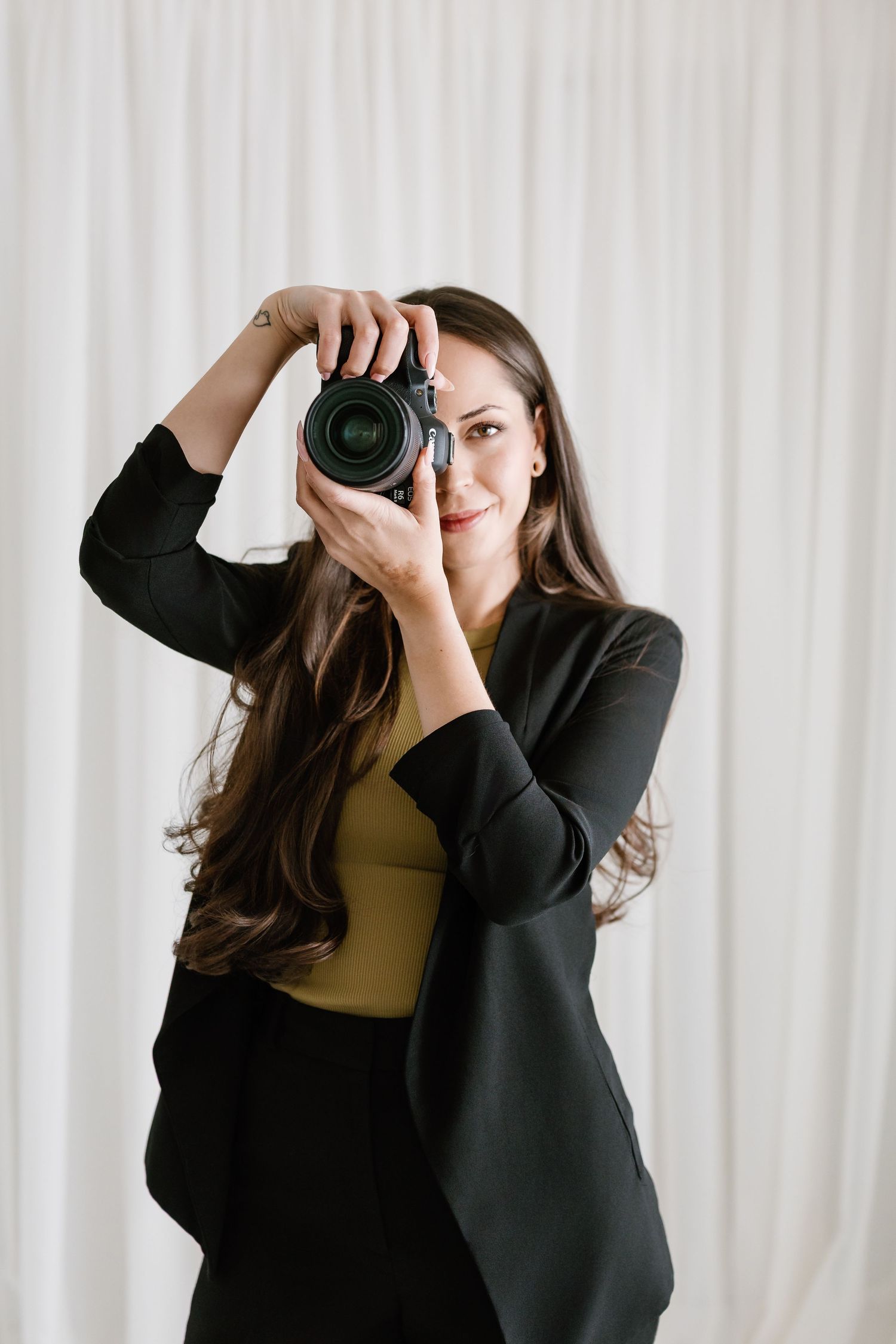 Series of shots showing photographer using professional camera against white backdrop.