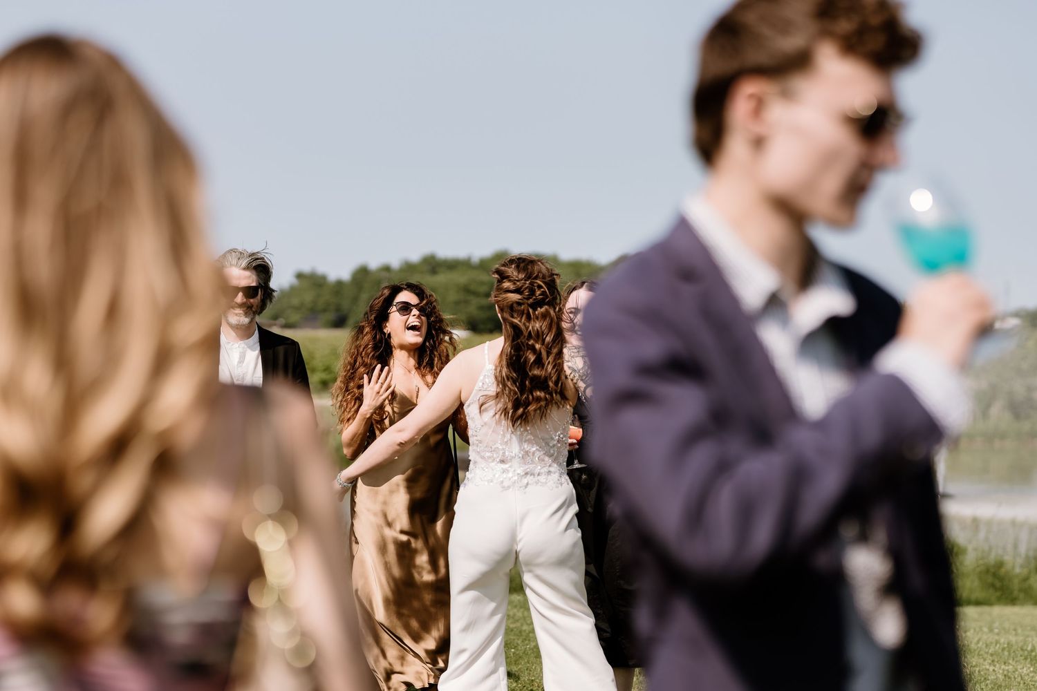 Wedding guests celebrating and laughing during outdoor reception.