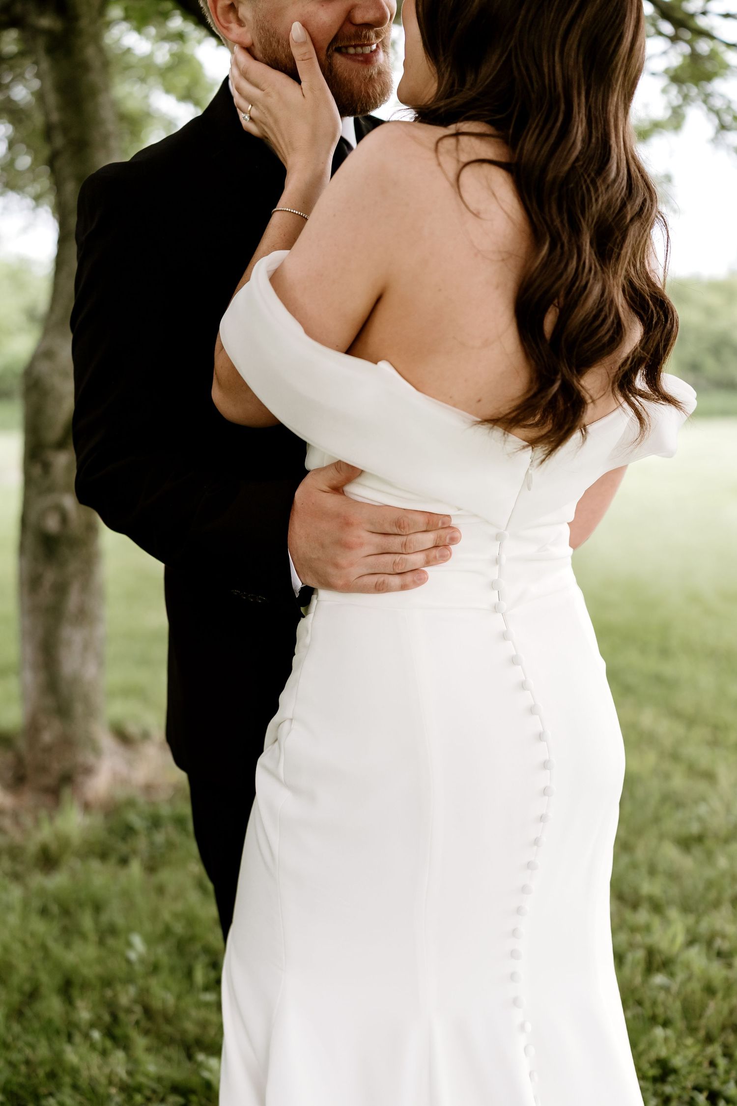 Close-up details of elegant white wedding dress buttons and fabric.