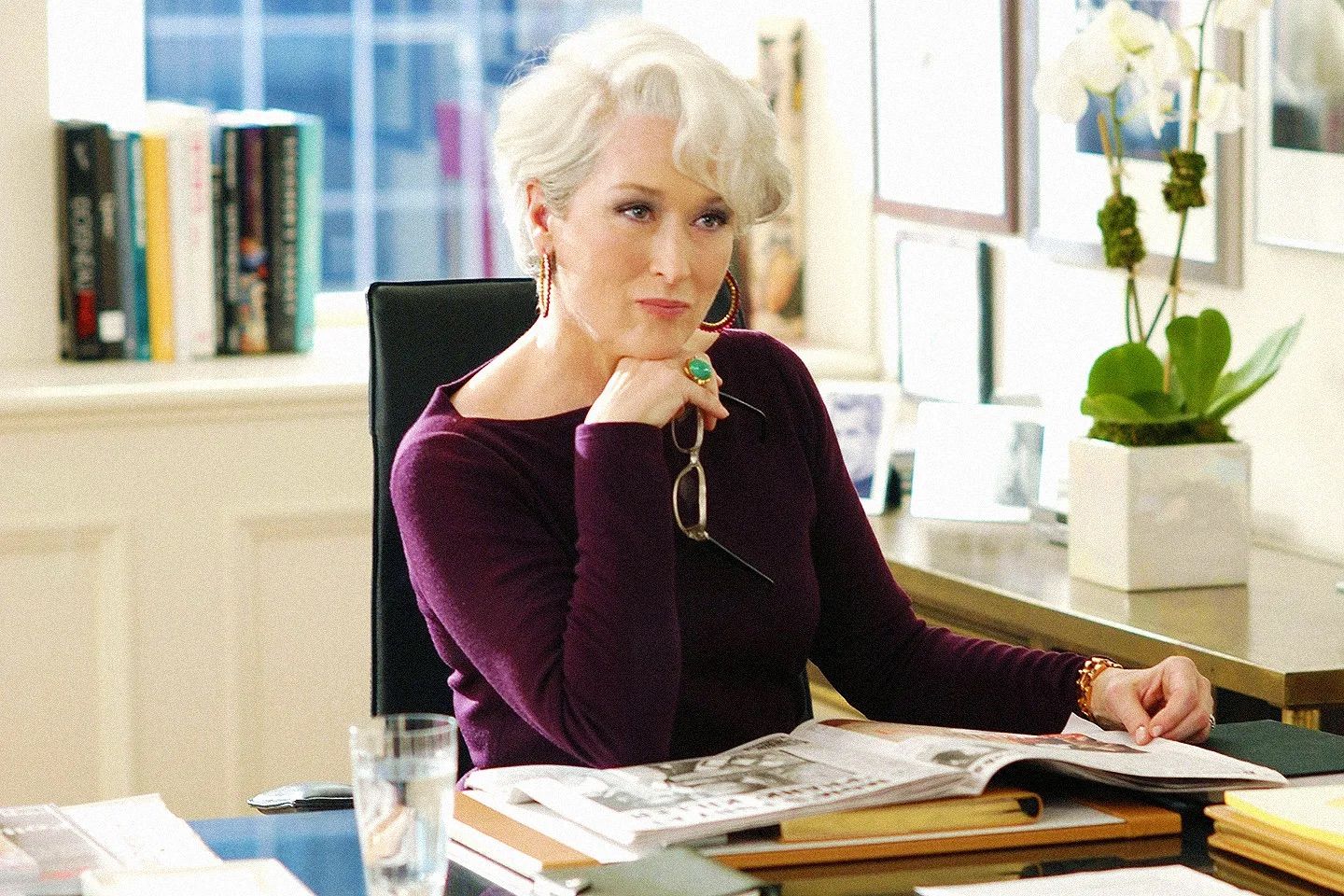 Woman reviewing documents at modern office desk with natural lighting.