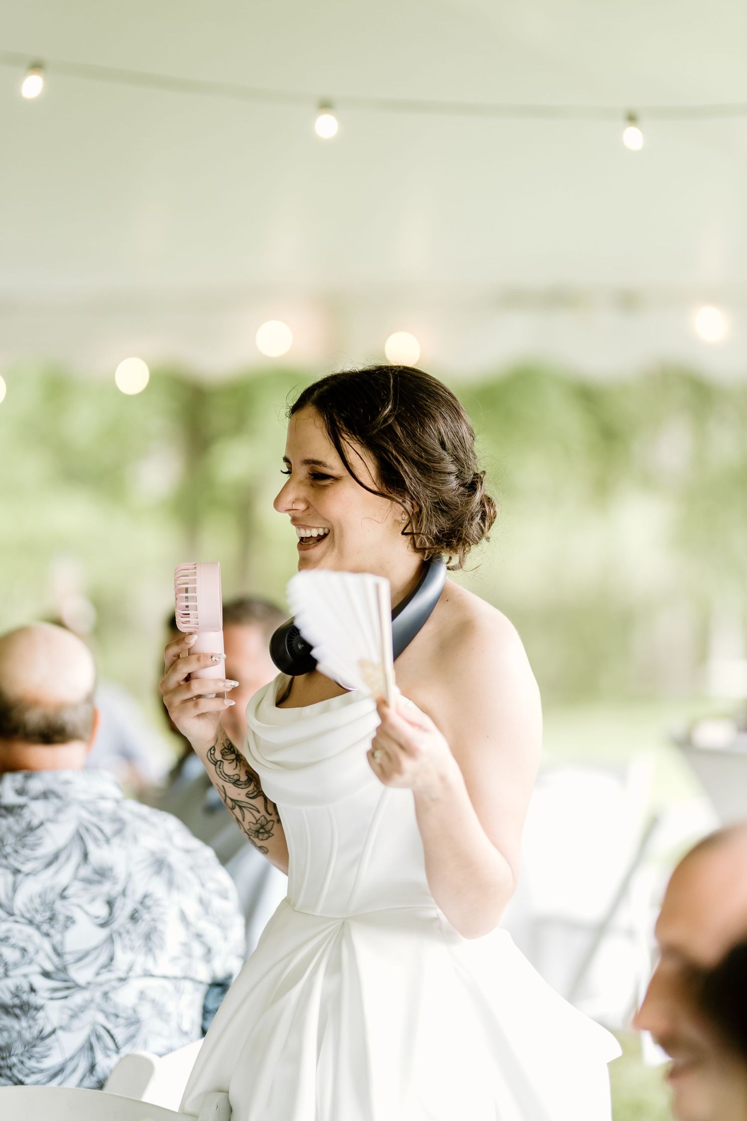 Wedding celebration under a white tent with joyful moments and natural lighting.