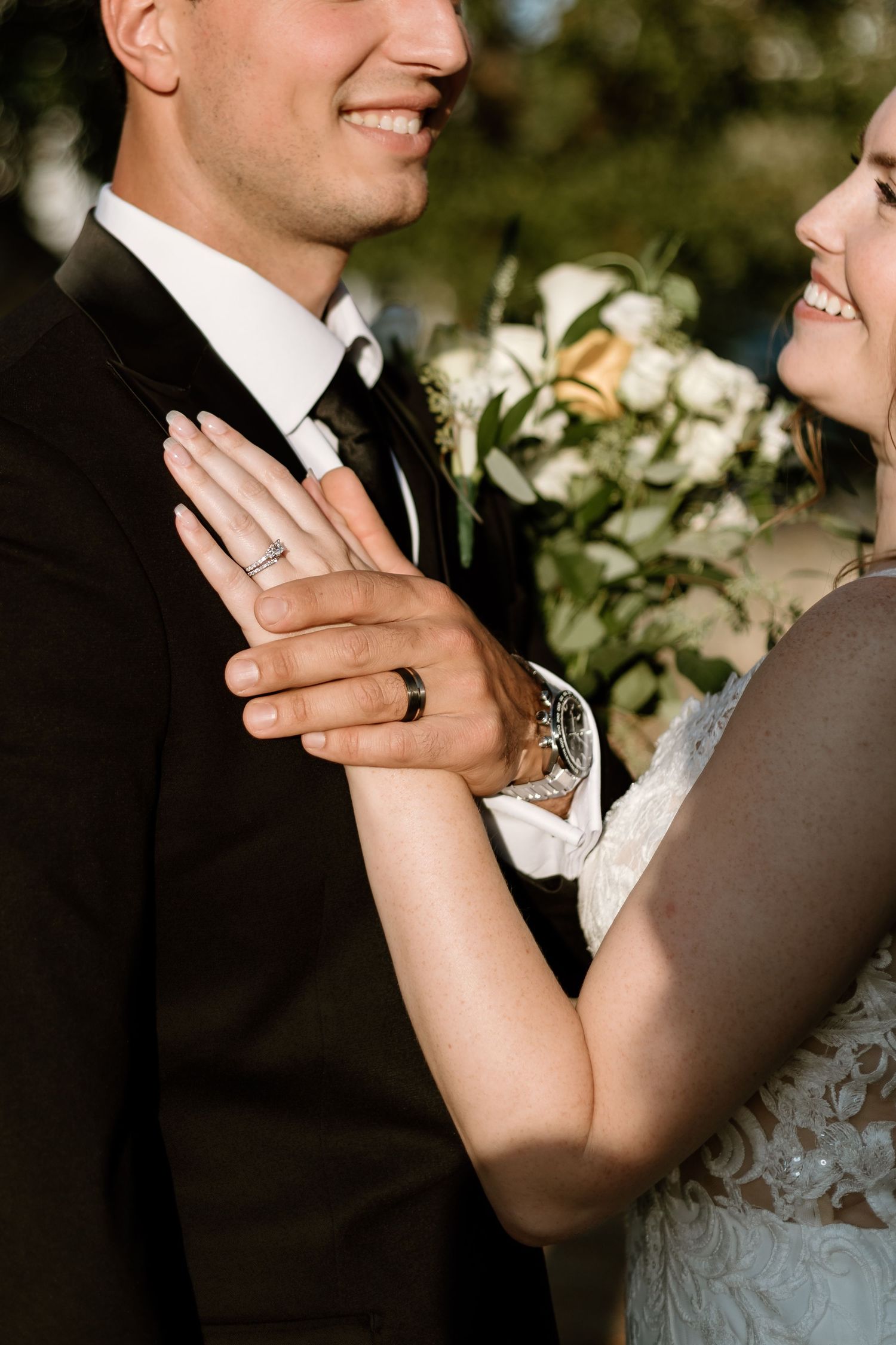 Close-up of wedding rings and hands during romantic outdoor portrait session.