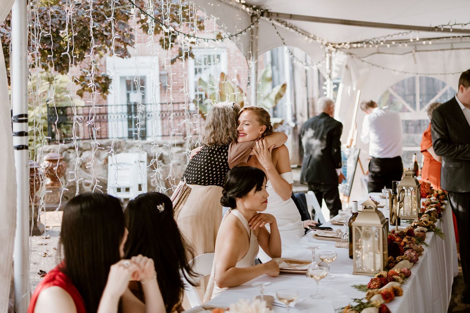 Wedding reception venue with string lights and white tent draping.