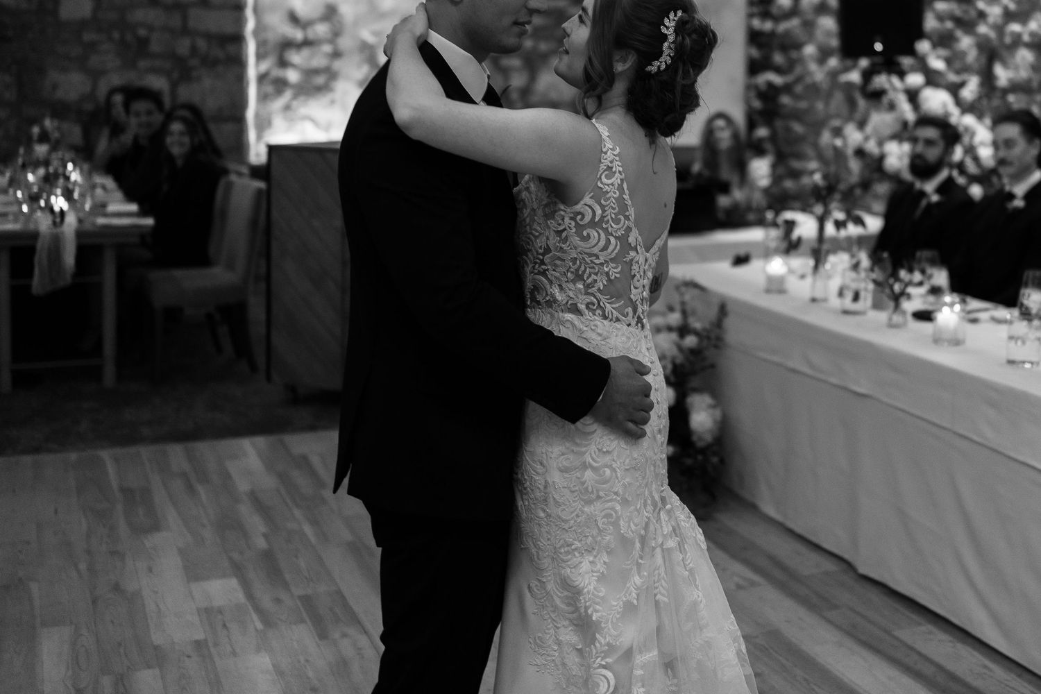 Black and white photo of a couple's first dance at their wedding reception.