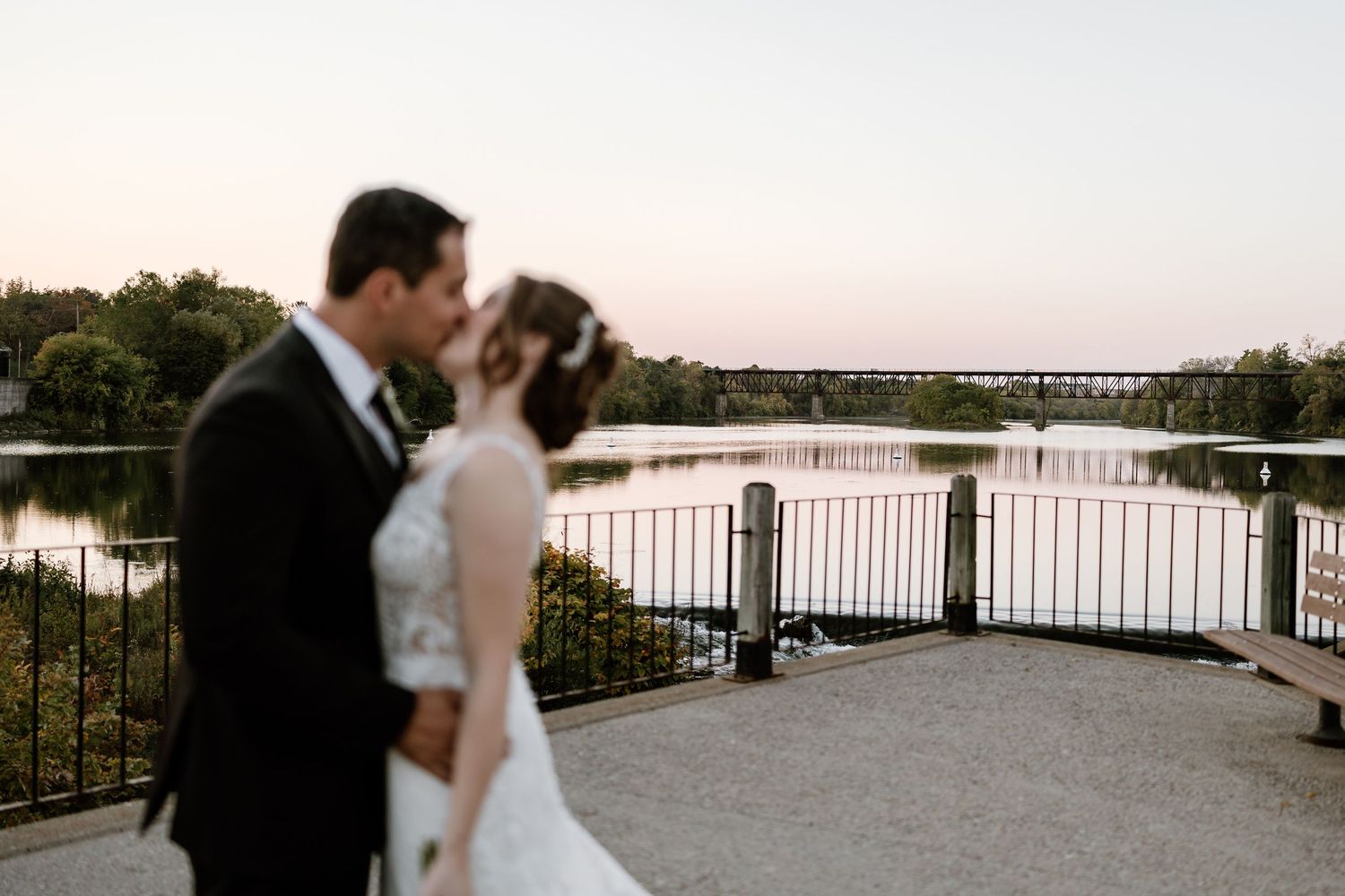 Romantic sunset wedding portraits on a waterfront terrace.