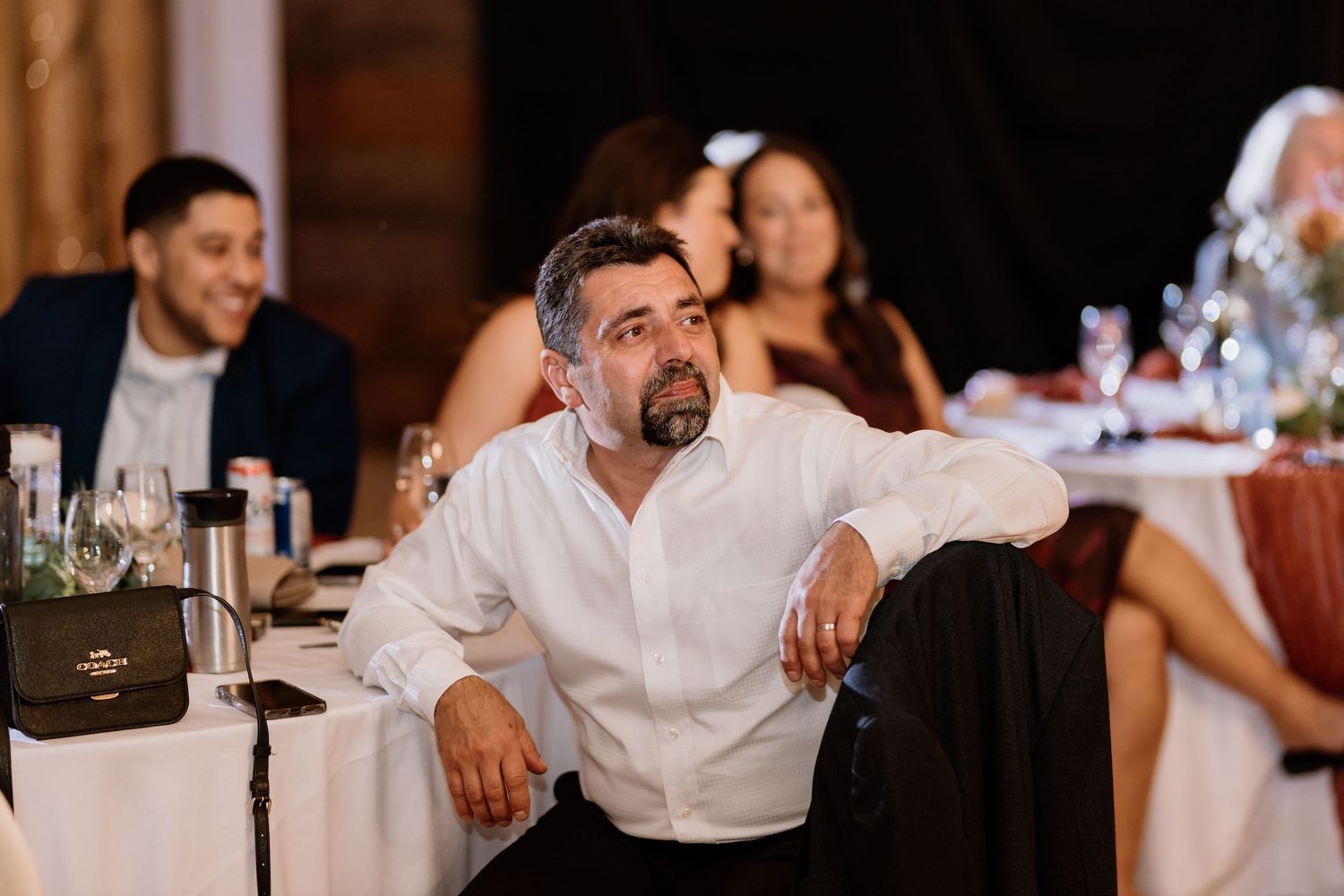 Wedding guests enjoying the celebration and dancing at a rustic barn reception.