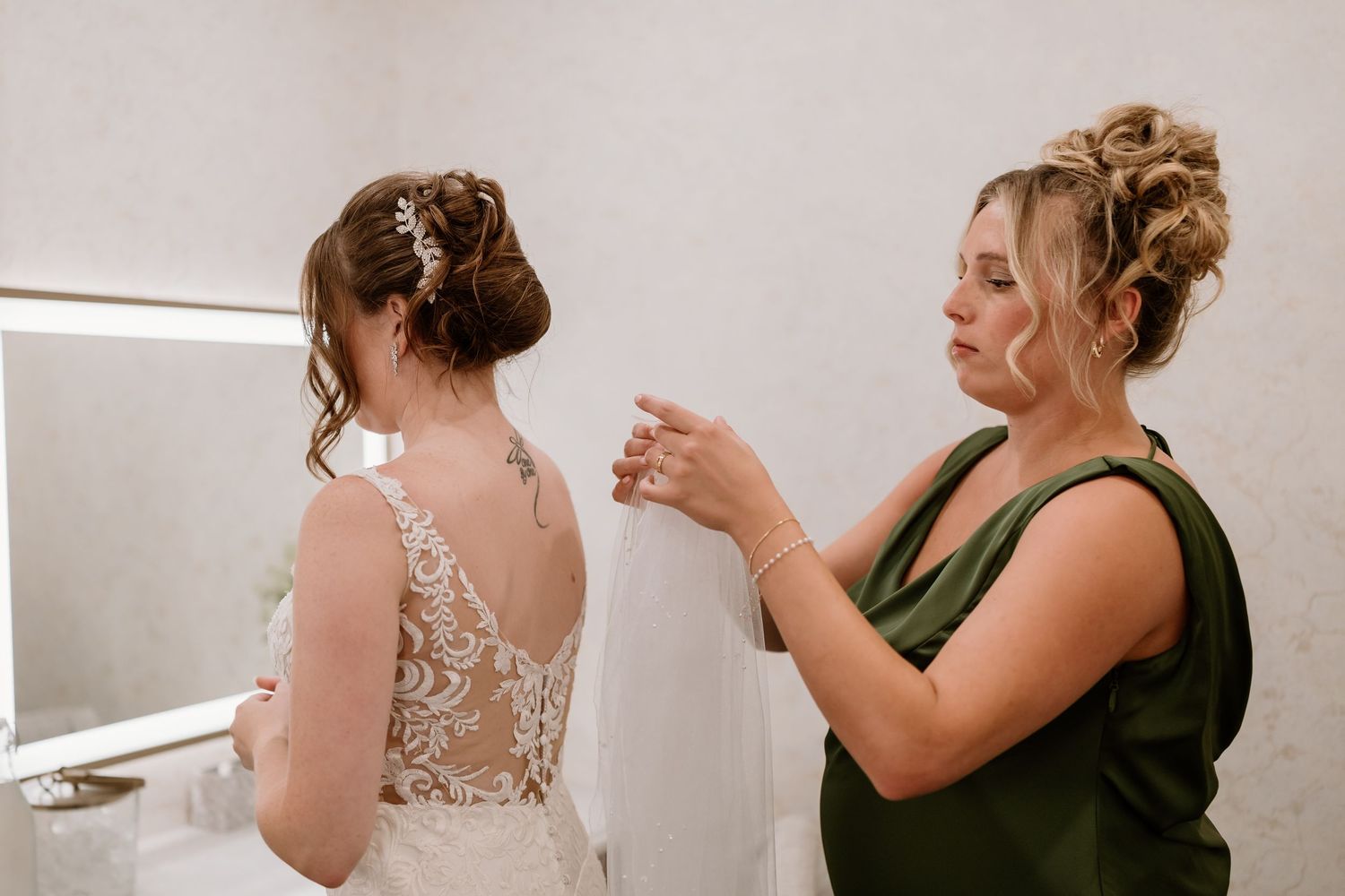 Candid moments during a bridal fitting session in a bright room.