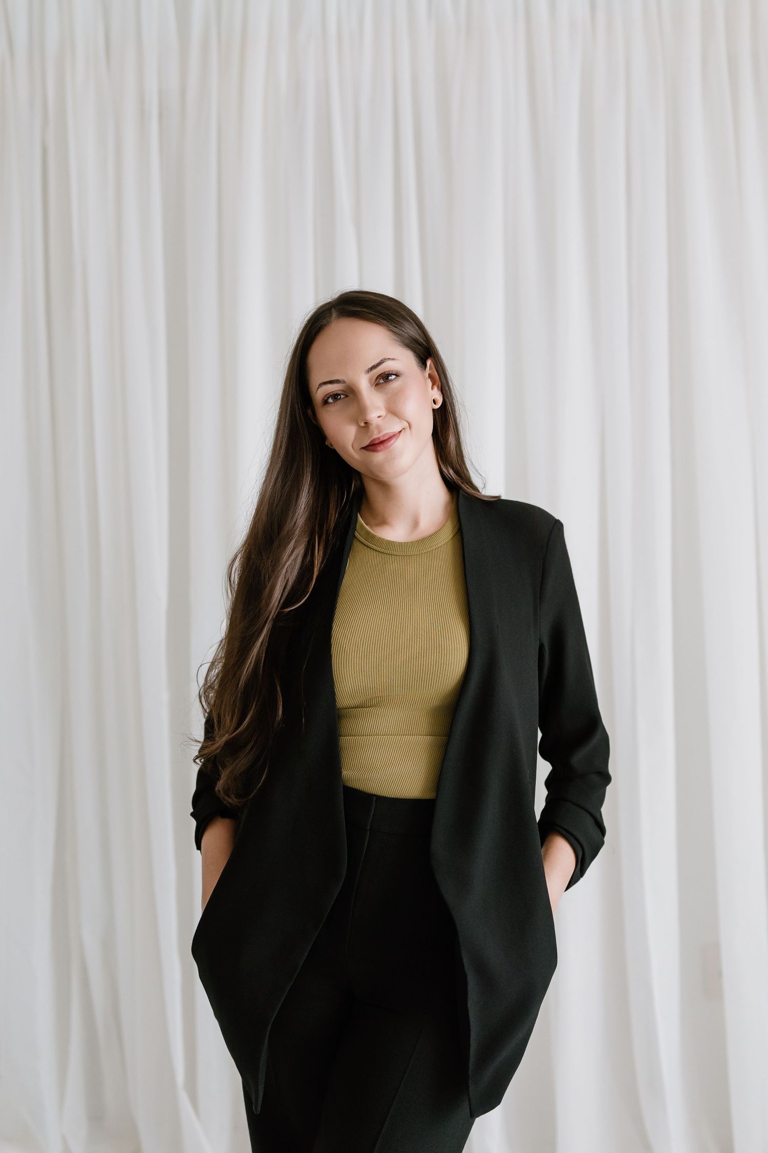 Candid poses of woman in black blazer and olive top against white studio background.