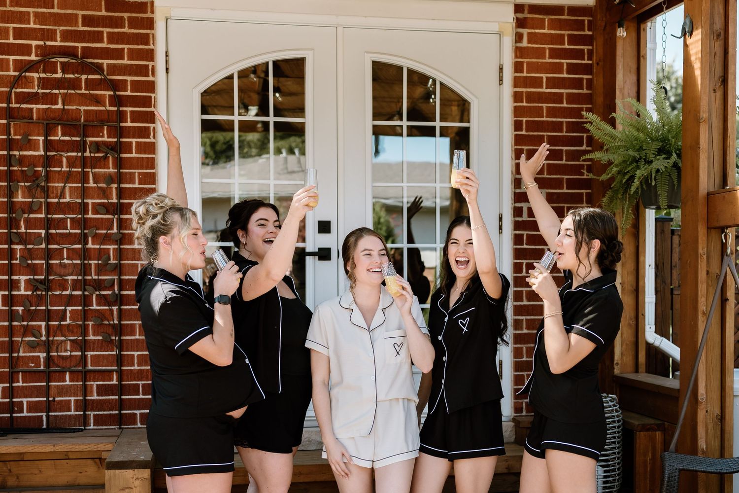 Candid celebration moments on brick porch with matching outfits.