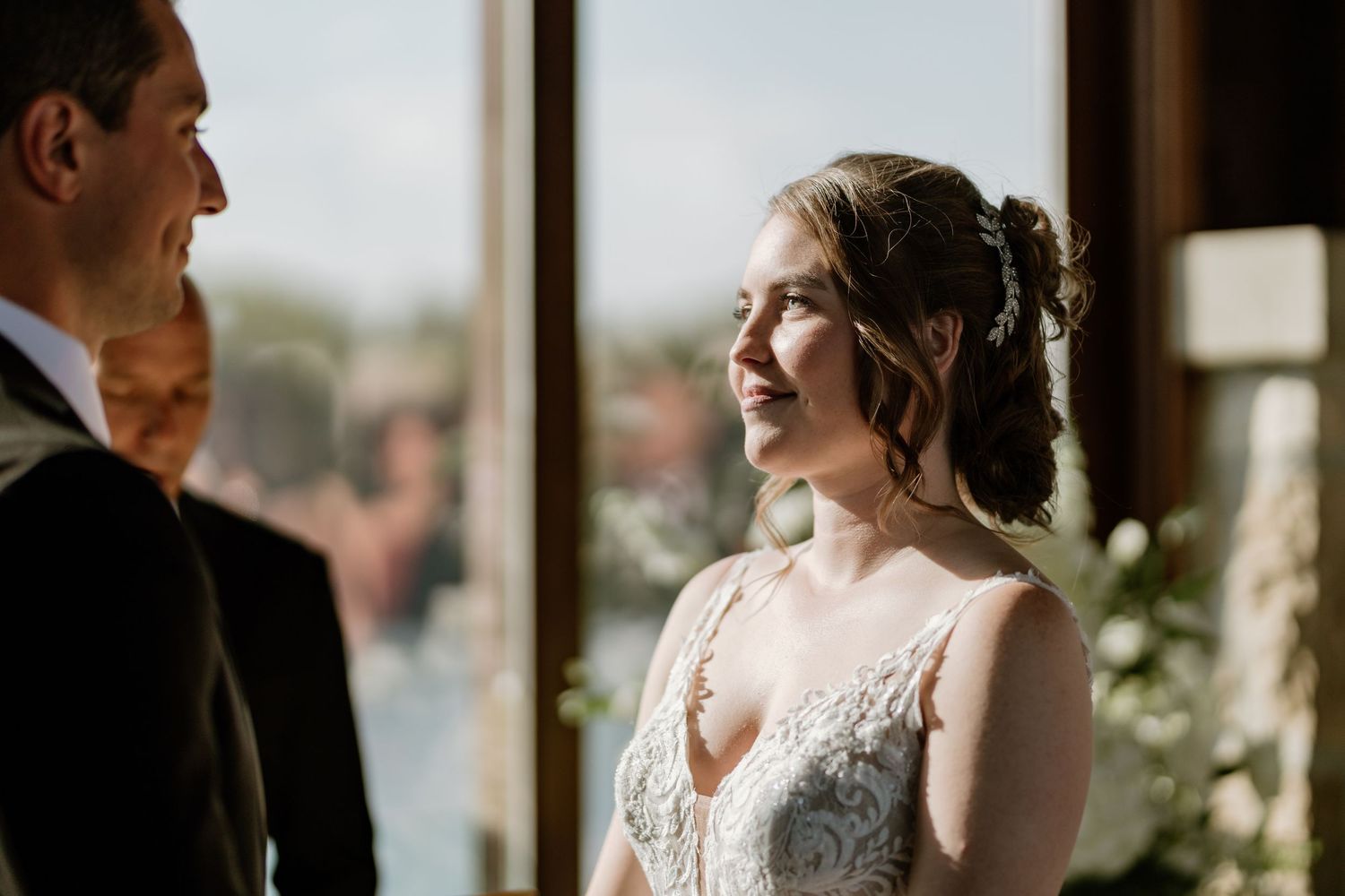 Intimate wedding ceremony moment captured against backdrop of panoramic windows.