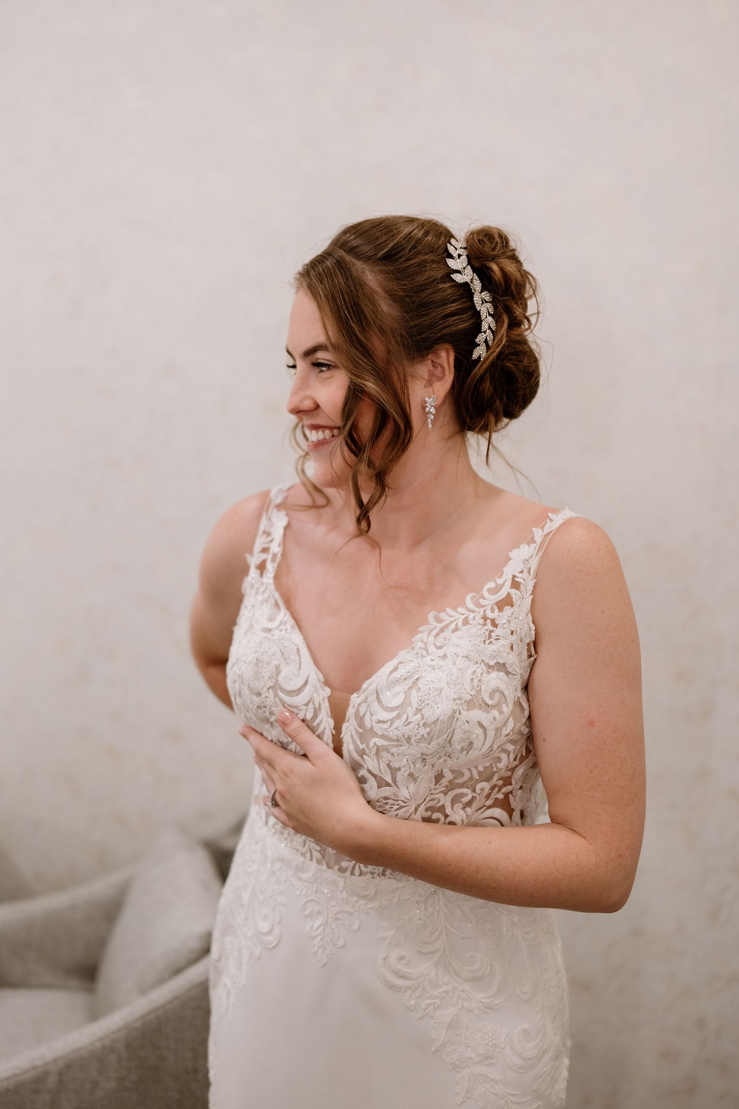 A beautiful lace wedding dress with intricate details being fitted and adjusted.