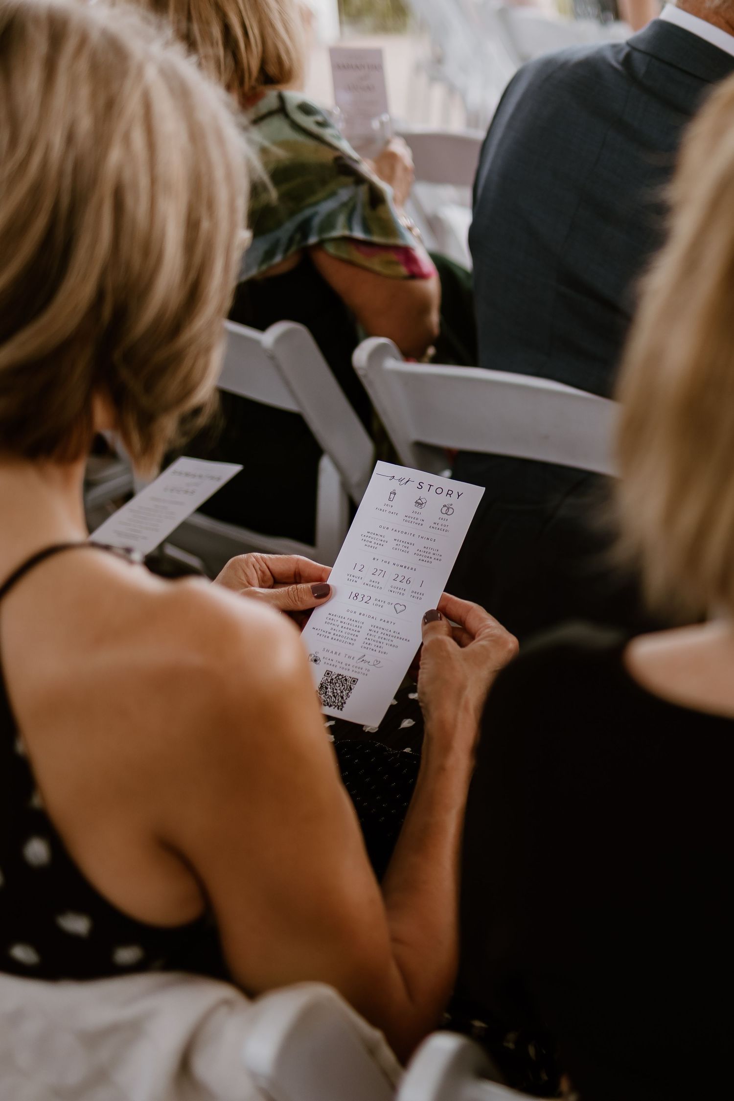 Wedding guests reading handwritten vows during an intimate ceremony.