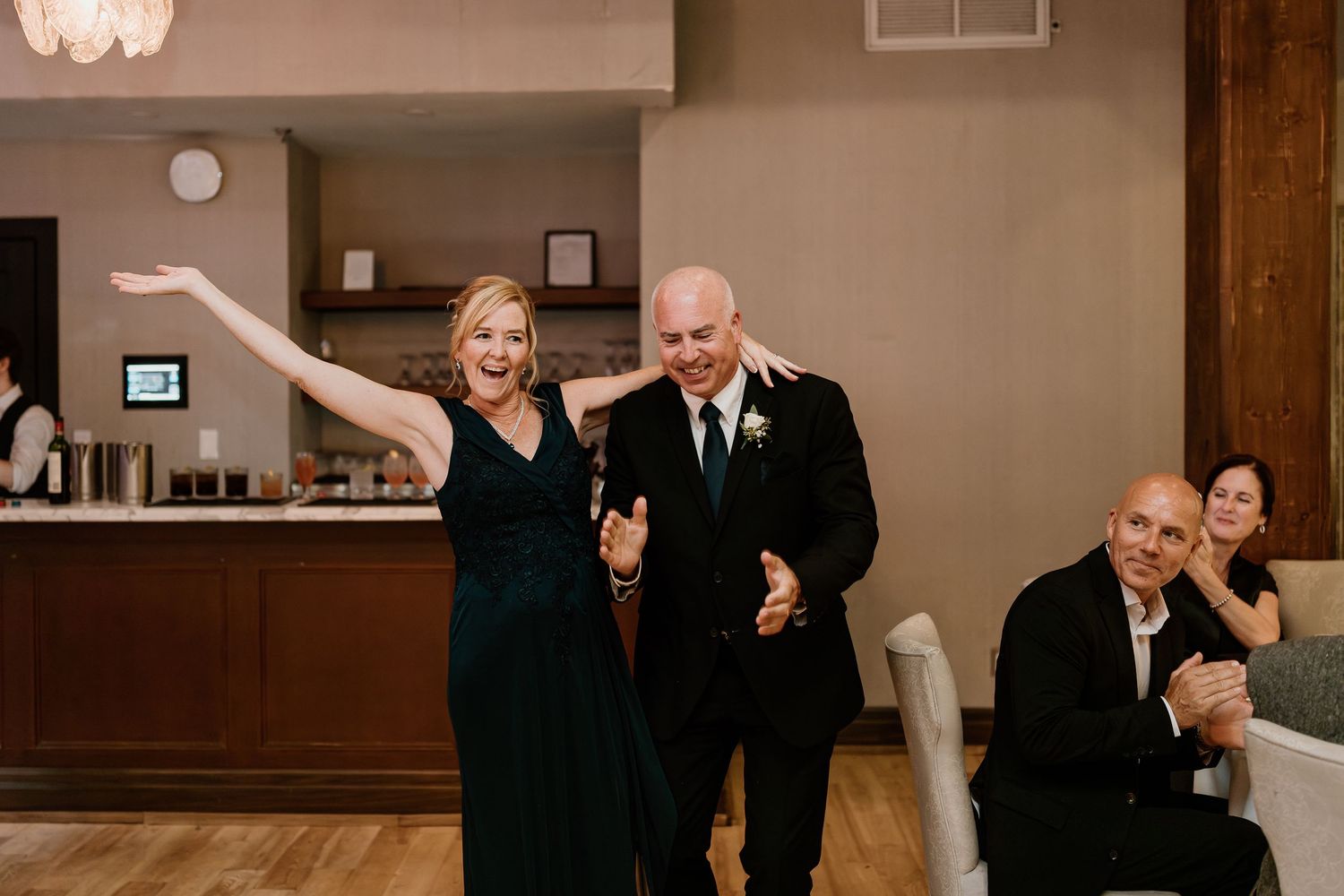 Wedding party celebrates with energetic dancing at indoor reception venue.