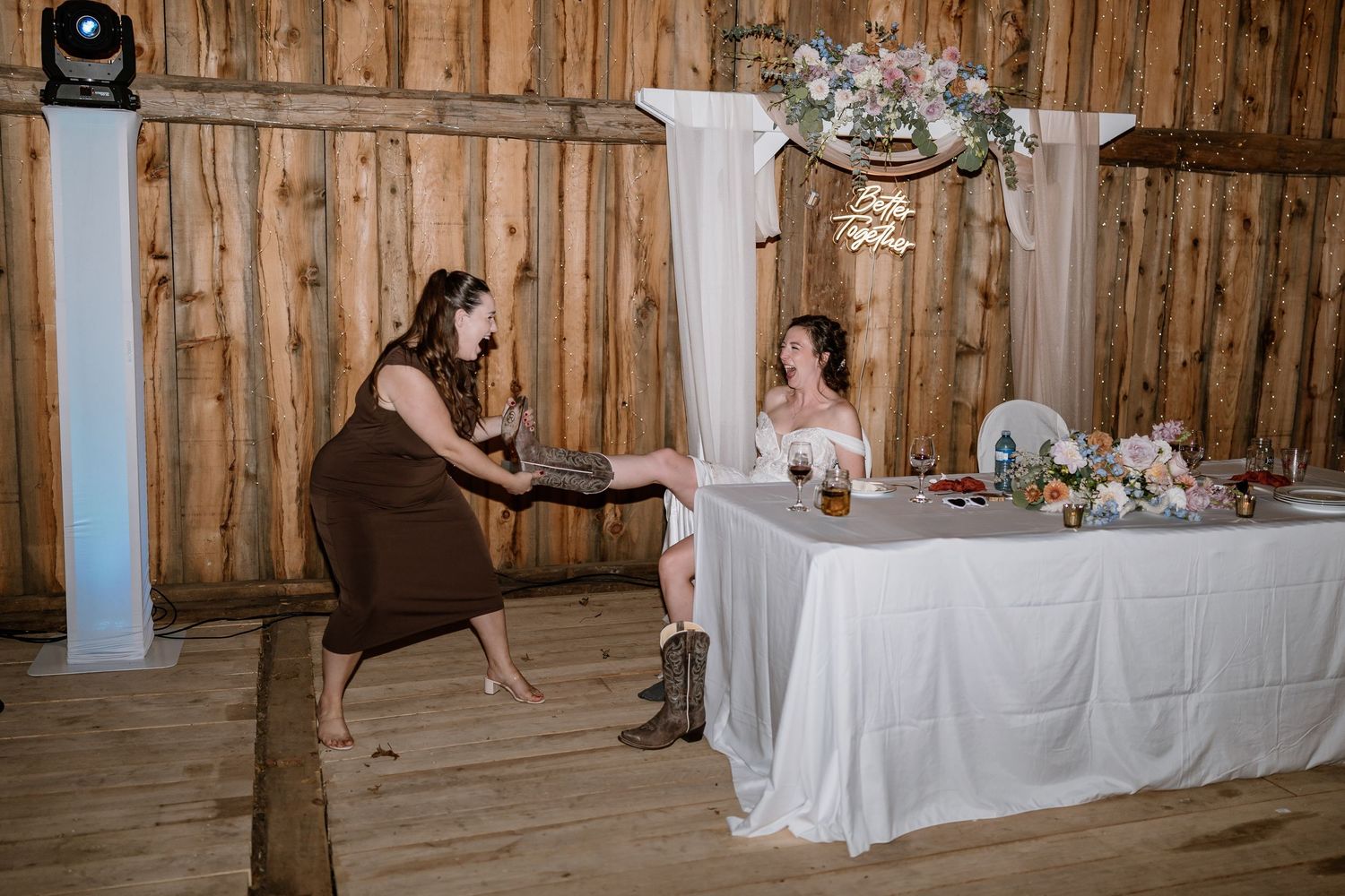 Rustic barn wedding reception with elegant table settings and string lights creating a warm ambiance.