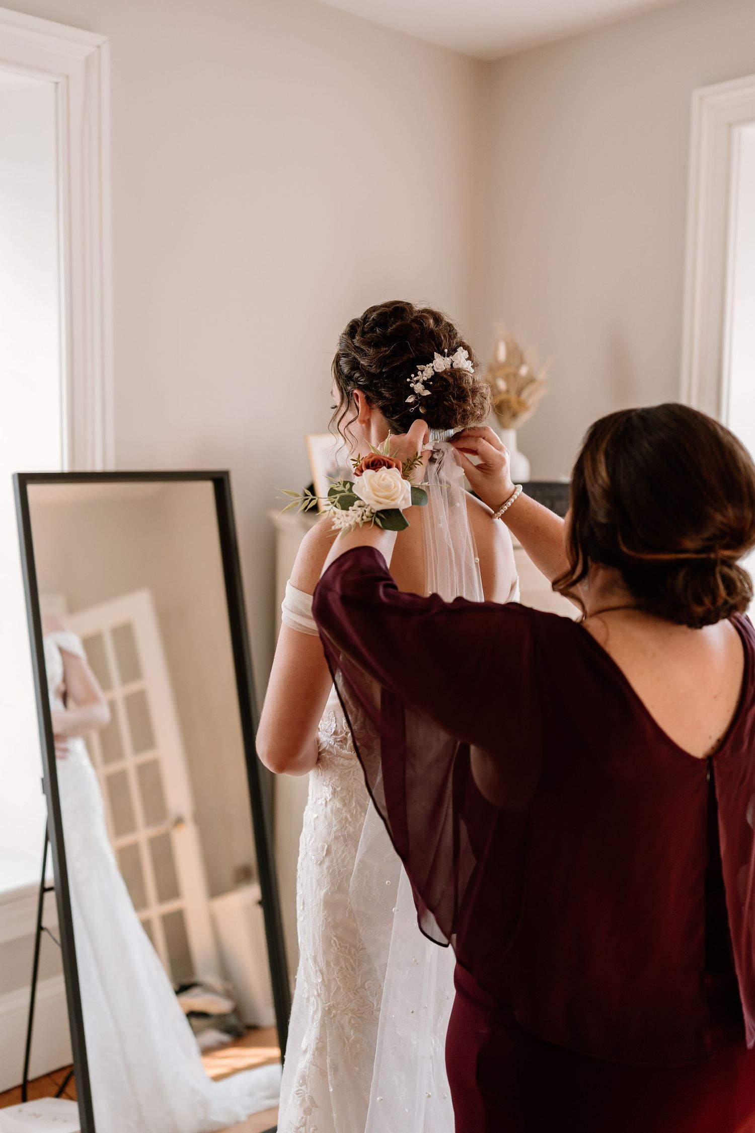 Wedding dress preparations in a bright room with white trim and window blinds.
