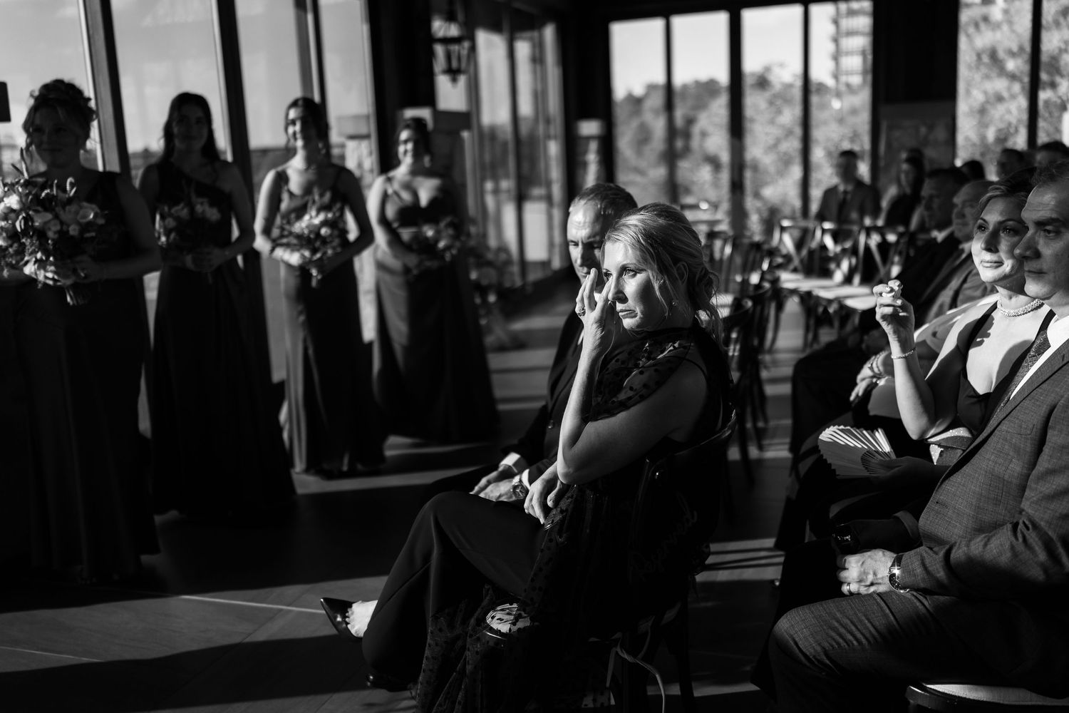 Black and white candid shots of wedding guests during an indoor reception.