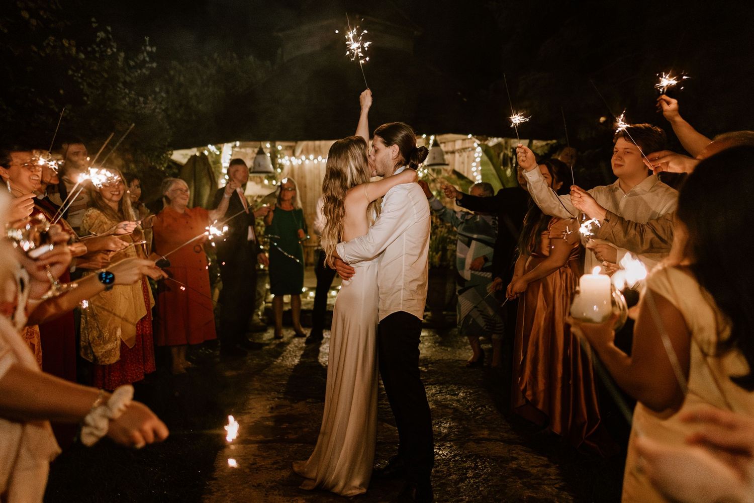 Nighttime celebration with sparklers creating a magical atmosphere outdoors.