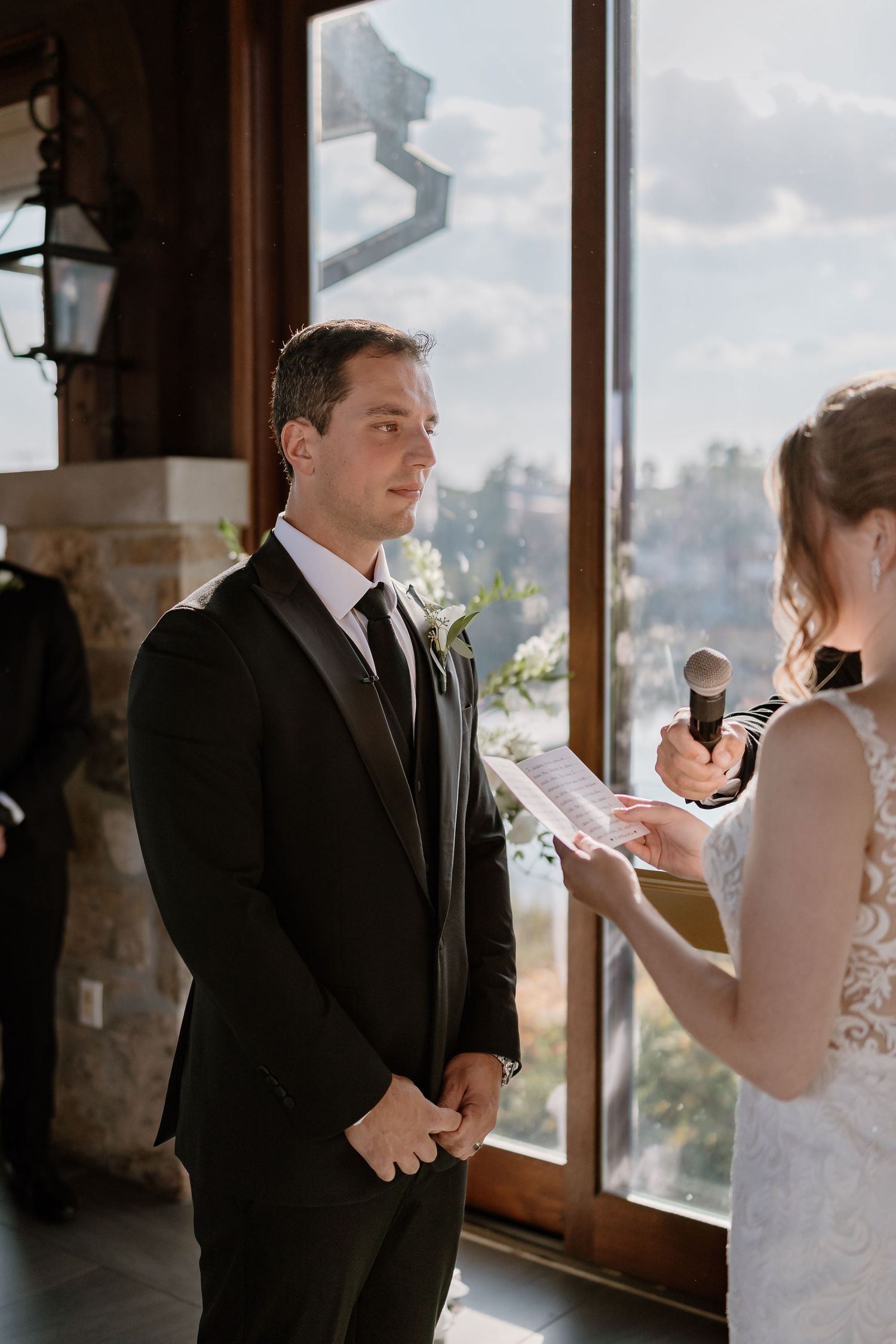 Wedding ceremony with couple exchanging vows in elegant venue with city views.